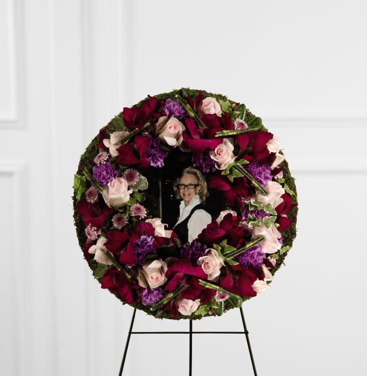 FTD Eternity Standing Easel - The FTD Eternity Standing Easel is a stunning way to capture the   memory of the departed at their final farewell service. Pink roses,   purple carnations, lavender button poms, magenta gladiolus, variegated   ivy and pittosporum greens are lovingly arranged to form a wreath   surrounding a favorite picture of the deceased. Displayed on a wire   easel, this arrangement is a moving way to honor their life and express   your unending love and affection.   no dimensions
