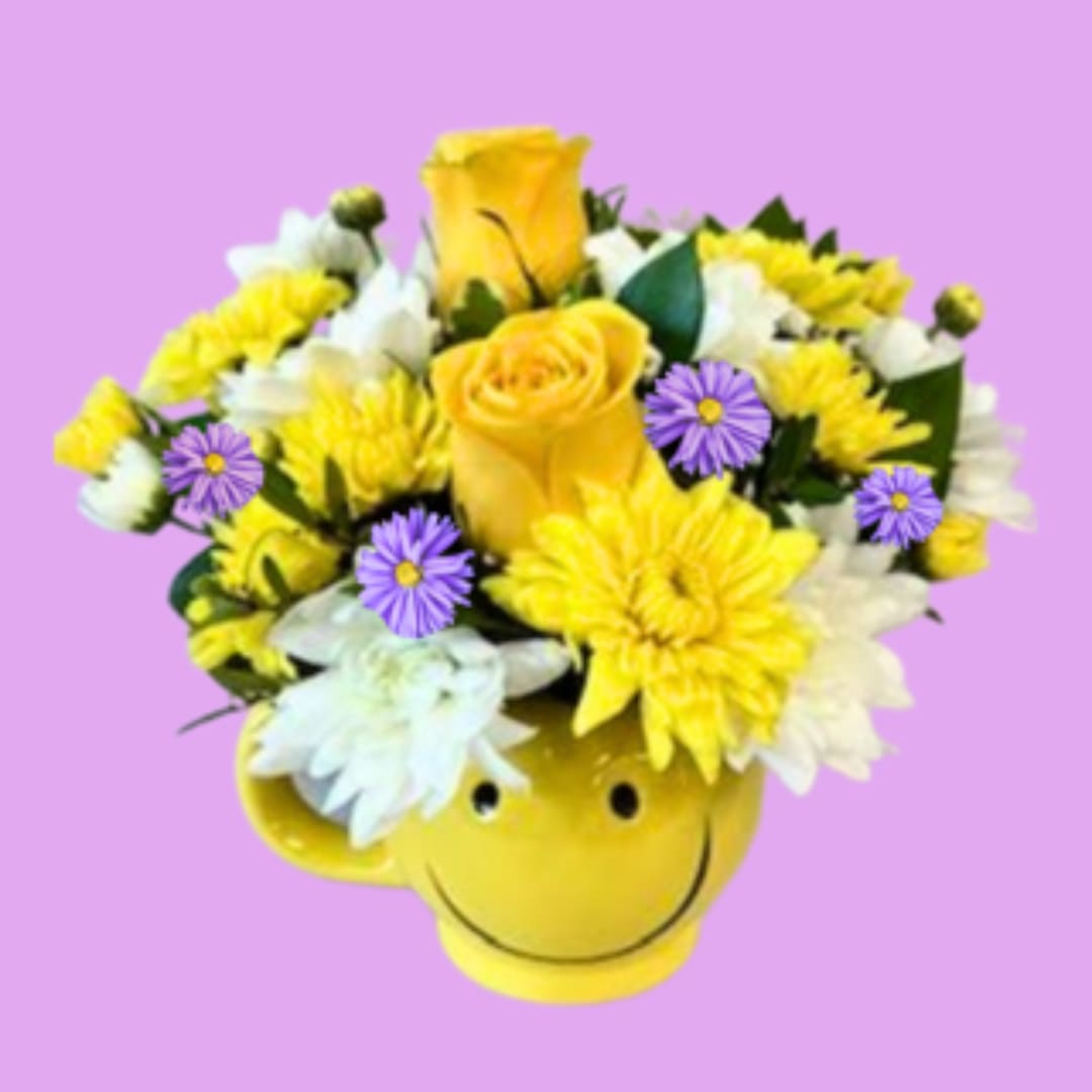 Yellow and white flower arrangement in a smiley-face mug