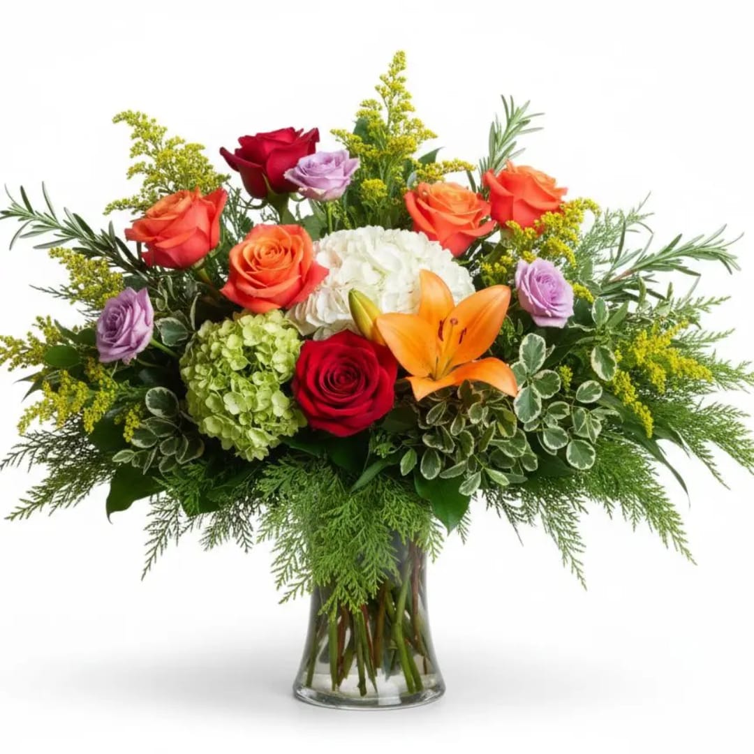 Mixed bouquet of roses, lilies, and hydrangea in a glass vase