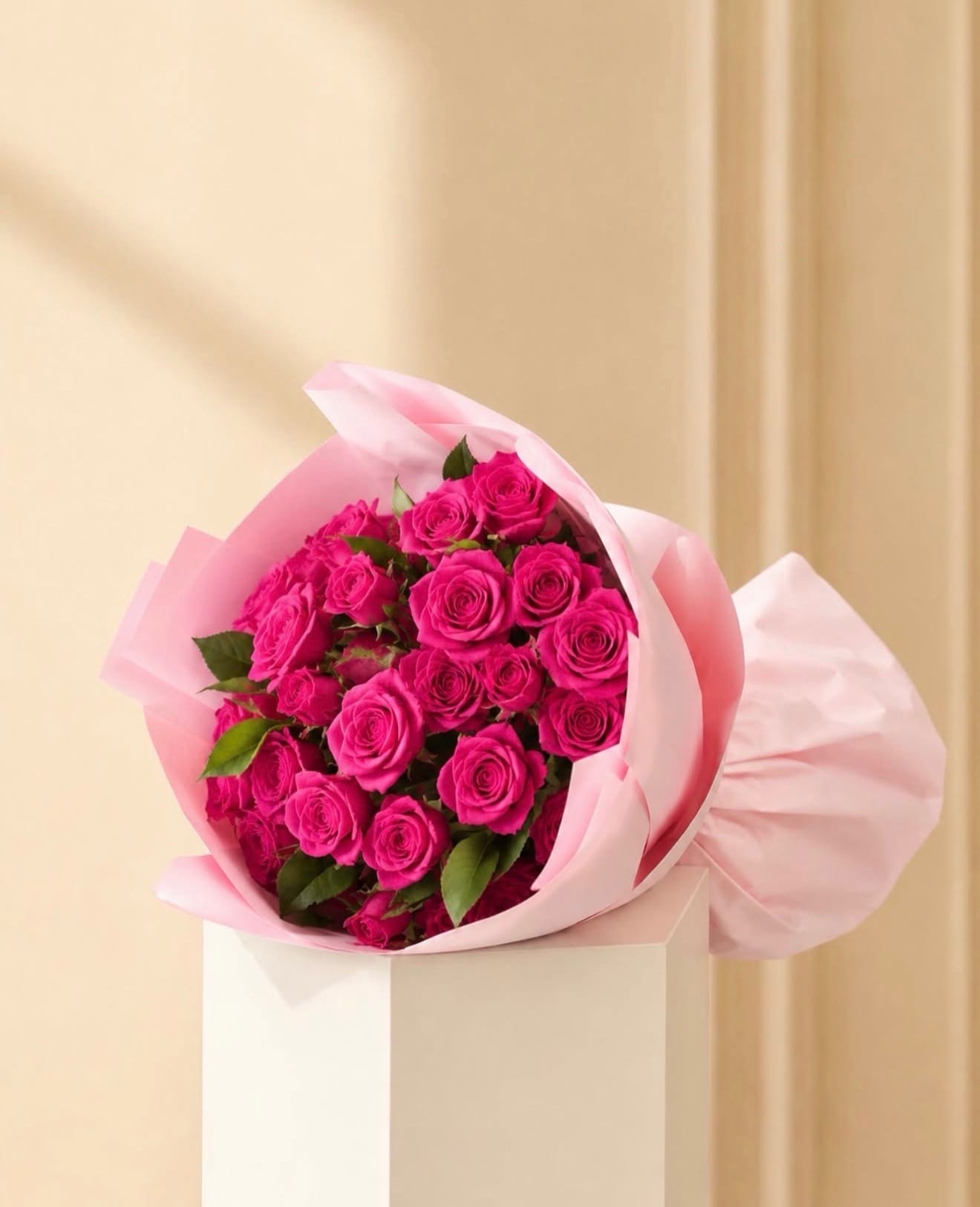 Bouquet of bright pink roses wrapped in pale pink paper