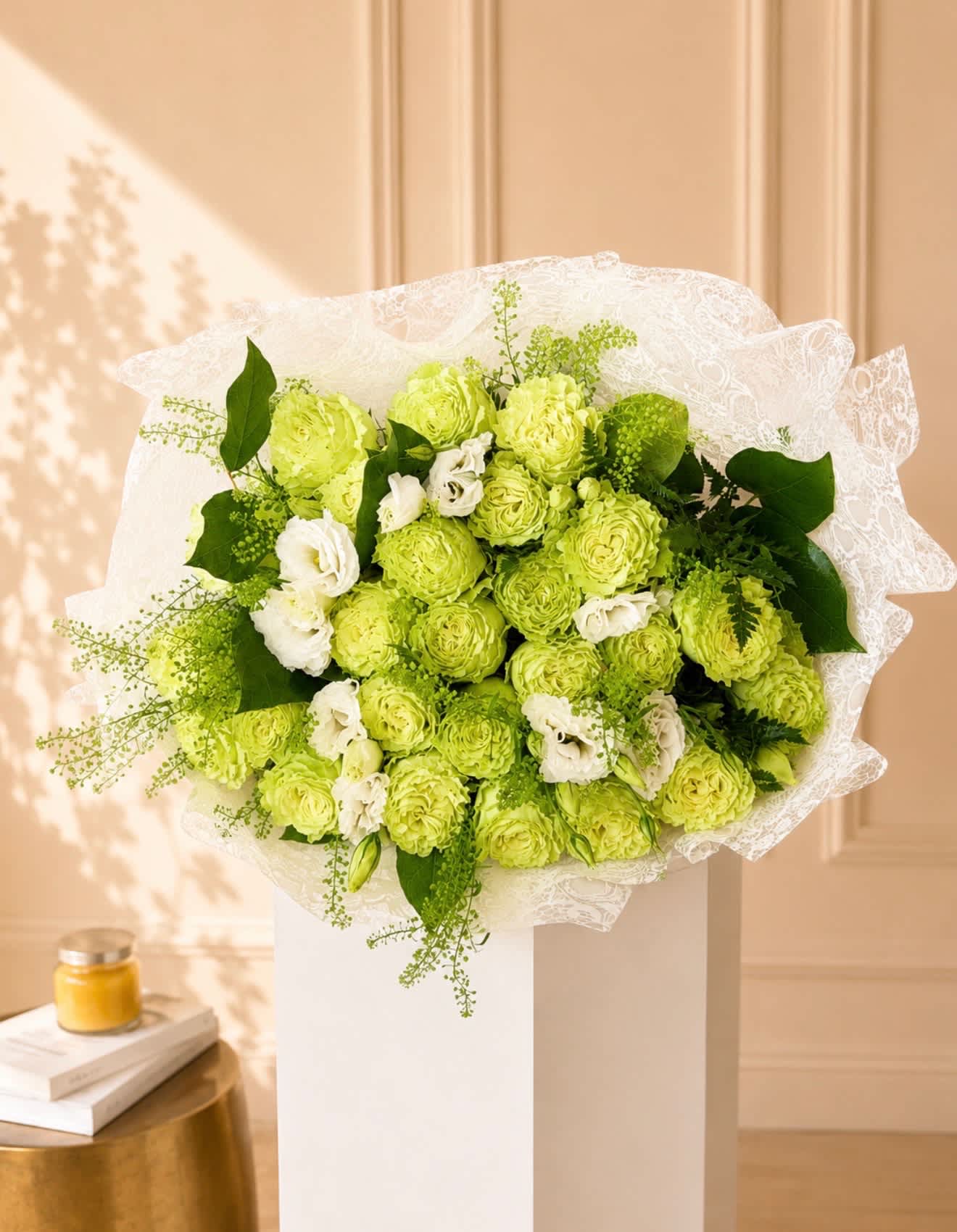 Bouquet of lime green and white flowers wrapped in white lace paper