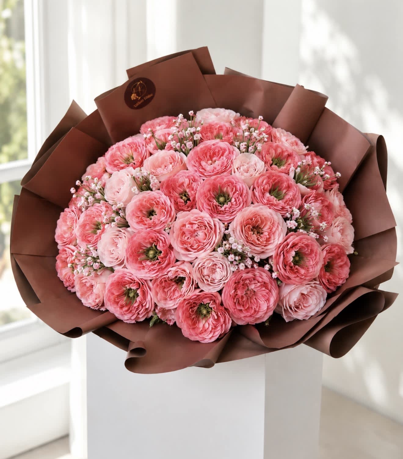 Bouquet of pink ranunculus wrapped in brown paper