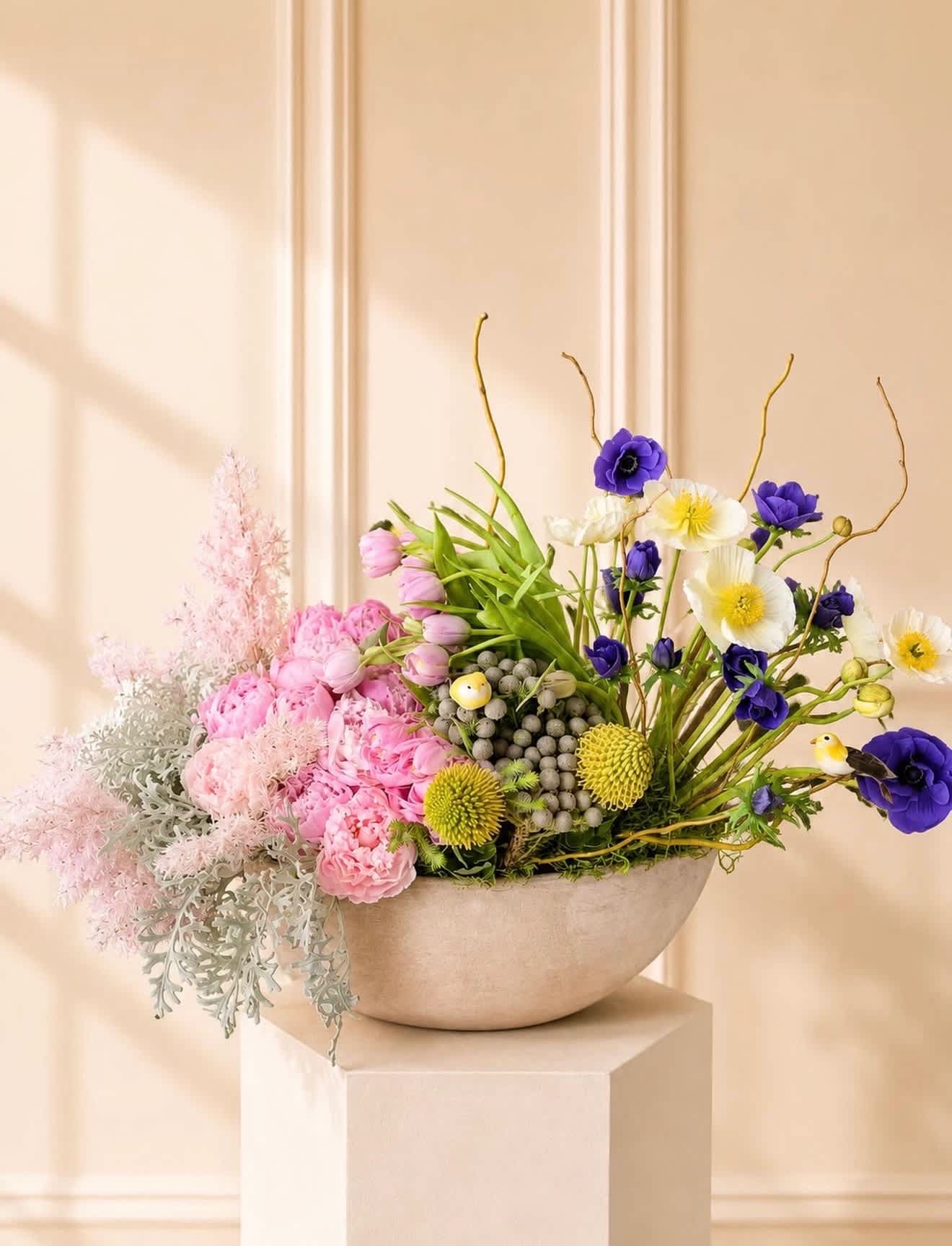Pink and purple mixed flower arrangement in a shallow bowl vase