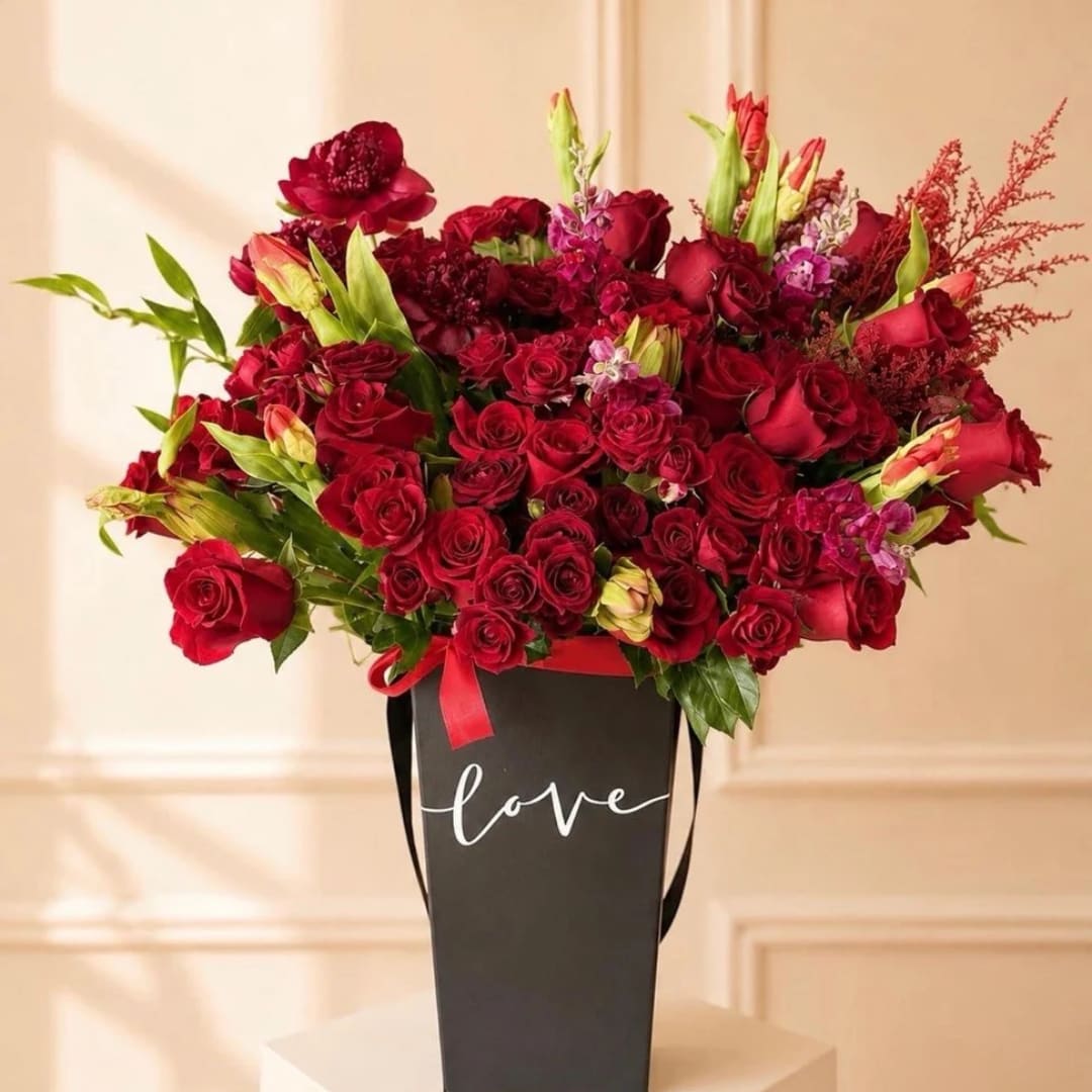 Red rose bouquet in a black box with the word love