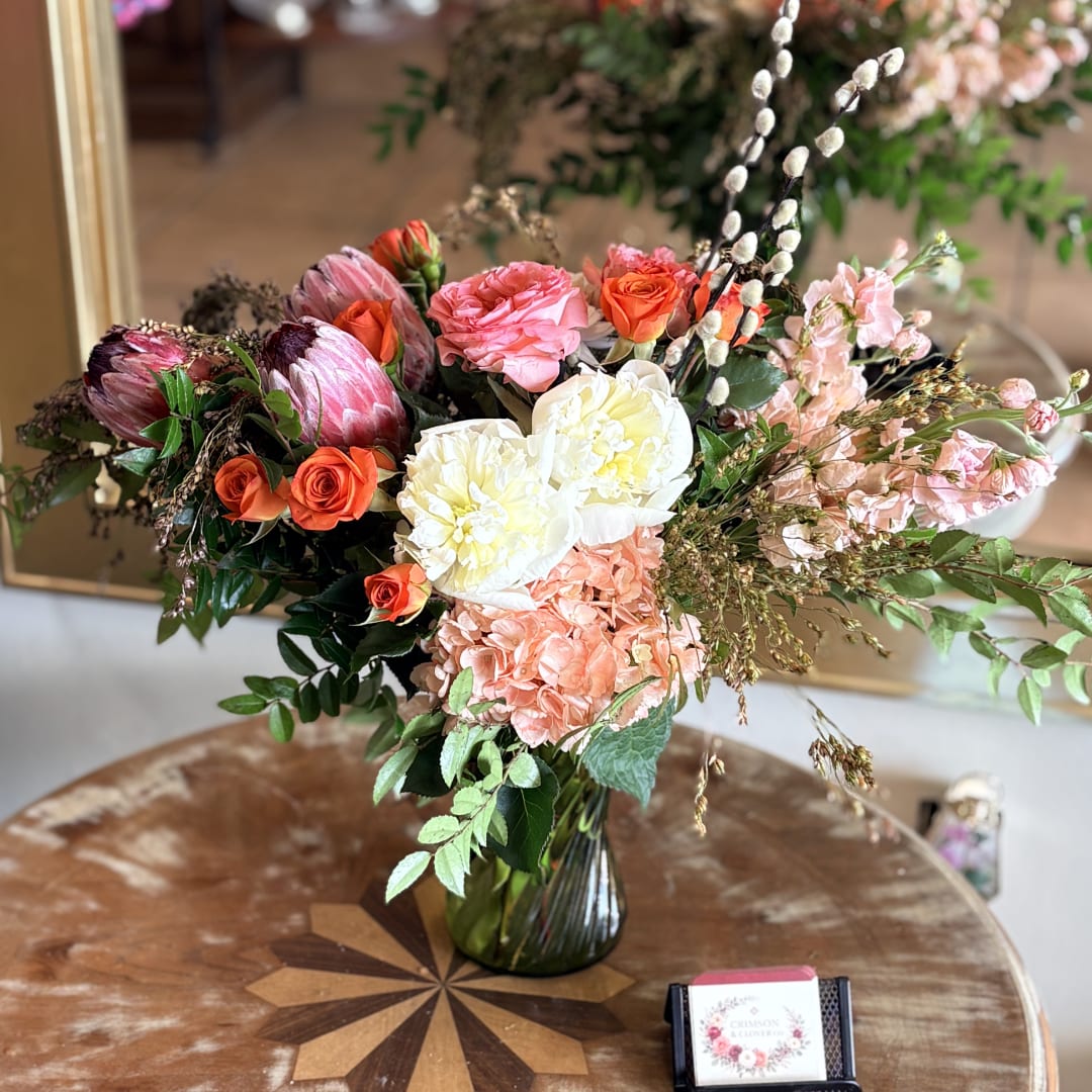 Mixed bouquet in a glass vase with pink, white, and orange blooms