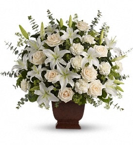 White lilies and cream roses arranged in a brown urn vase