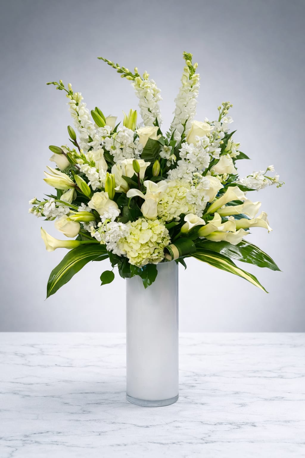 White floral arrangement in a tall glass vase
