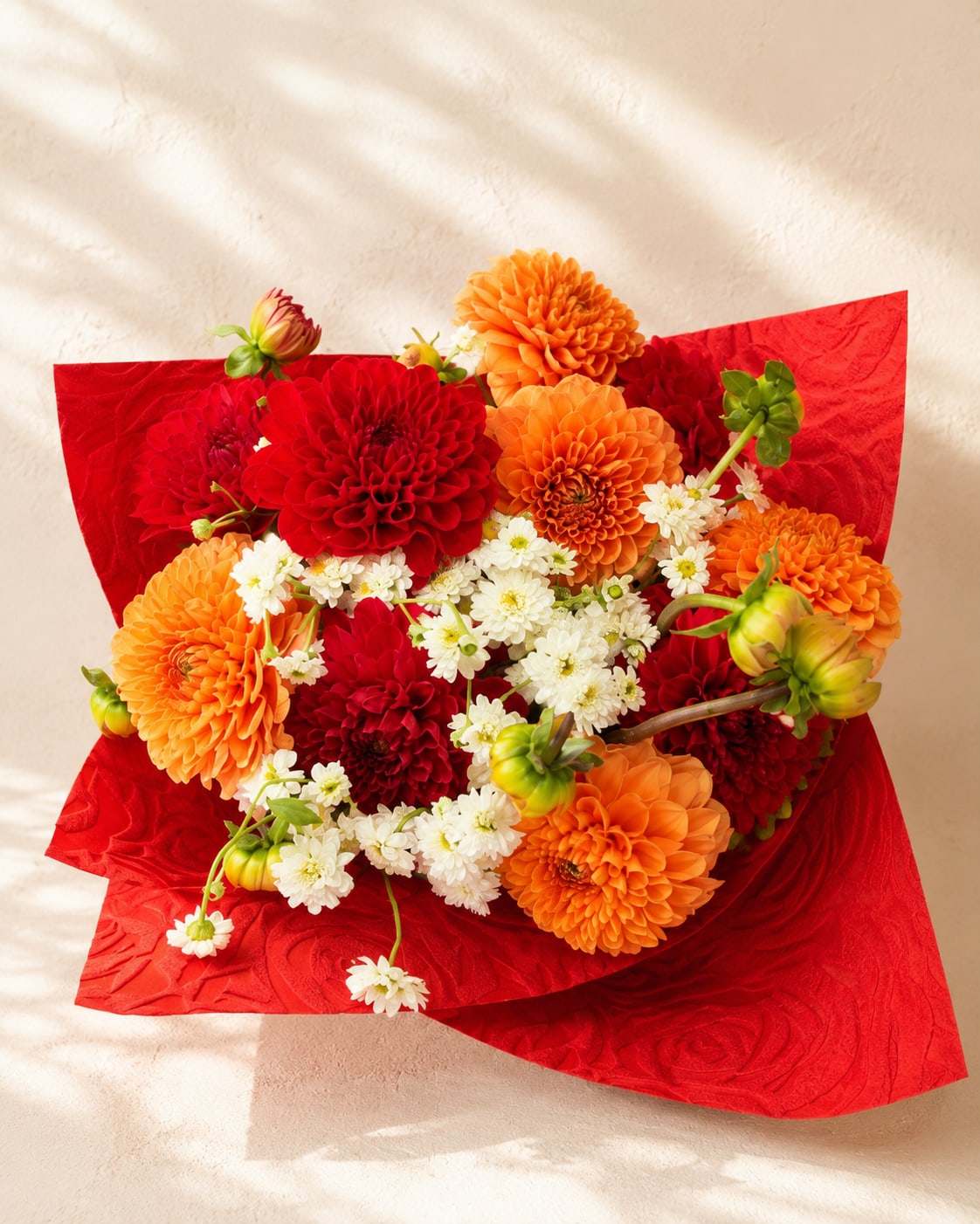 Antheia's Summer Garden – Seasonal Dahlia Bouquet - Antheia's Summer Garden captures the vibrant spirit of summer with a rich blend of premium seasonal dahlias in fiery red and sunset orange, softened by delicate white spray chrysanthemums. Inspired by Antheia, the Greek goddess of blossoms, this handcrafted bouquet celebrates nature's most colorful season.  Each arrangement is thoughtfully designed by Flower Fairy using the freshest seasonal blooms available, making every bouquet naturally unique while preserving its luxurious style and vibrant color palette.  Perfect for birthdays, celebrations, congratulations, thank-you gifts, or simply bringing the warmth and beauty of summer into someone's day.  Features: Premium seasonal dahlias Handcrafted by Flower Fairy Luxury waterproof wrapping Fresh seasonal flowers Same-day flower delivery throughout the Phoenix Metro Area Designed by your local Phoenix florist
