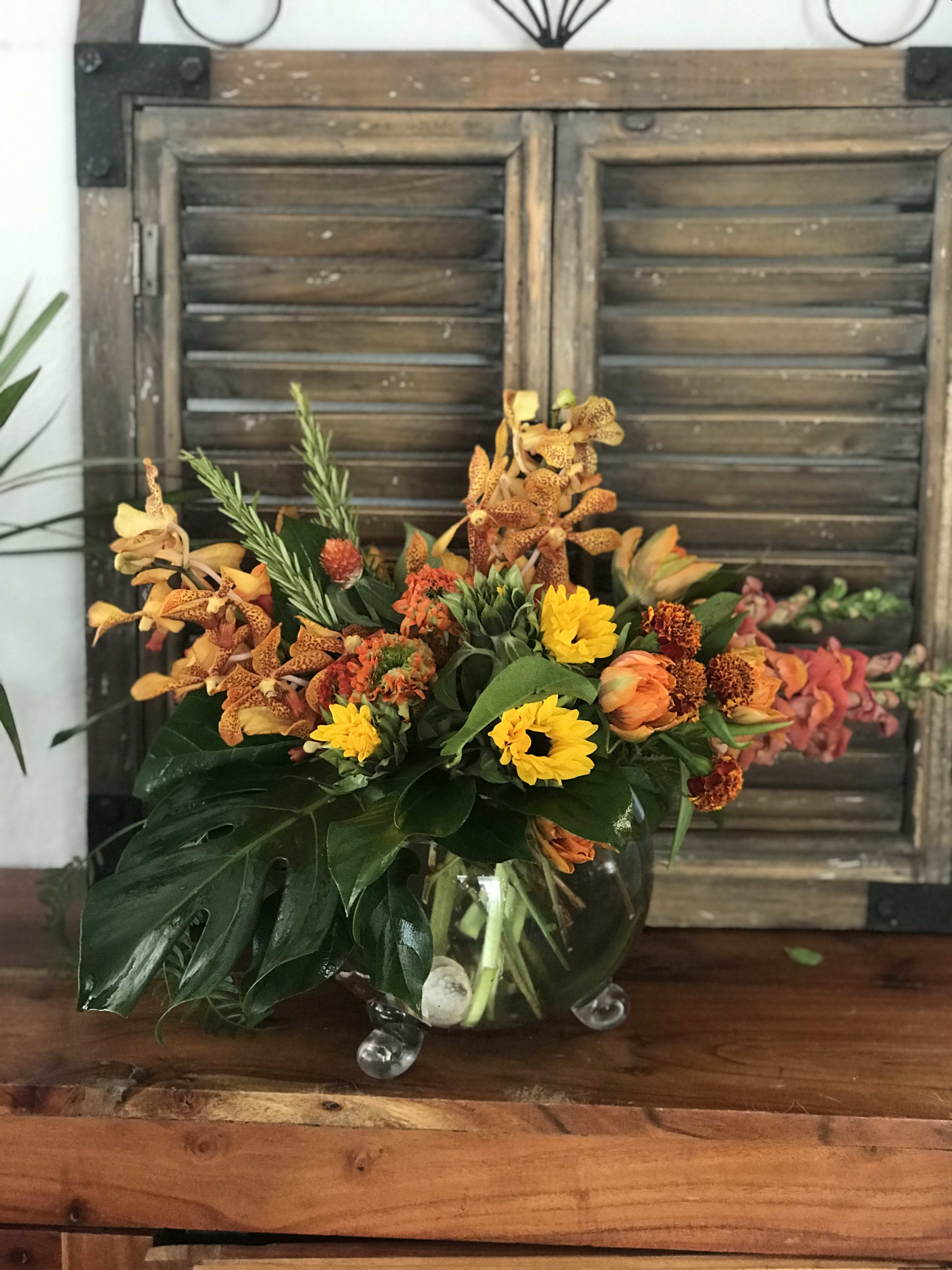 Orange and yellow floral arrangement in a clear glass vase