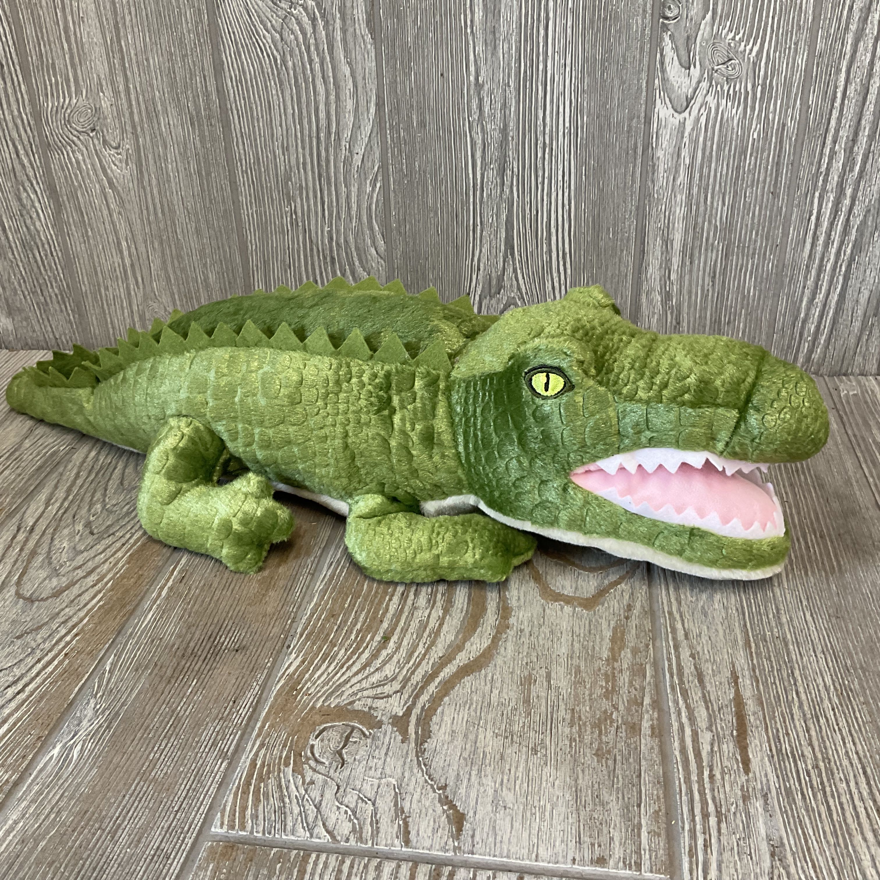 Alligator Plushie 19" Zoologee Earth Keepers  - A bright green alligator plush makes an immediate, playful impression-perfect as a whimsical birthday gift, baby shower surprise, or get-well companion. This 19-inch plushie reads as friendly and fun: scaly-texture fabric, a long cuddly body, and an open mouth lined in pink with soft white teeth create a cartoonish, kid-friendly look that will make the recipient smile. Made with recycled materials and baby safe embroidered eyes.  Soft, durable construction in vivid green with accents of pink, white, and black means it stands up to squeezes and hugs while keeping its cheerful shape. As a non-floral gift from The Plant Shoppe Florist, it pairs beautifully with bouquets or can stand alone as a thoughtful keepsake for little ones or anyone who needs a comforting, lighthearted pick-me-up. Ideal for same-day occasion deliveries-add it to an arrangement or order by itself for a quick way to brighten someone's day.
