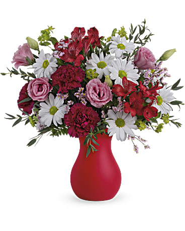 Mixed bouquet of pink and white flowers in a red vase