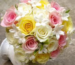 Bouquet of pink, yellow, and white roses with white blossoms