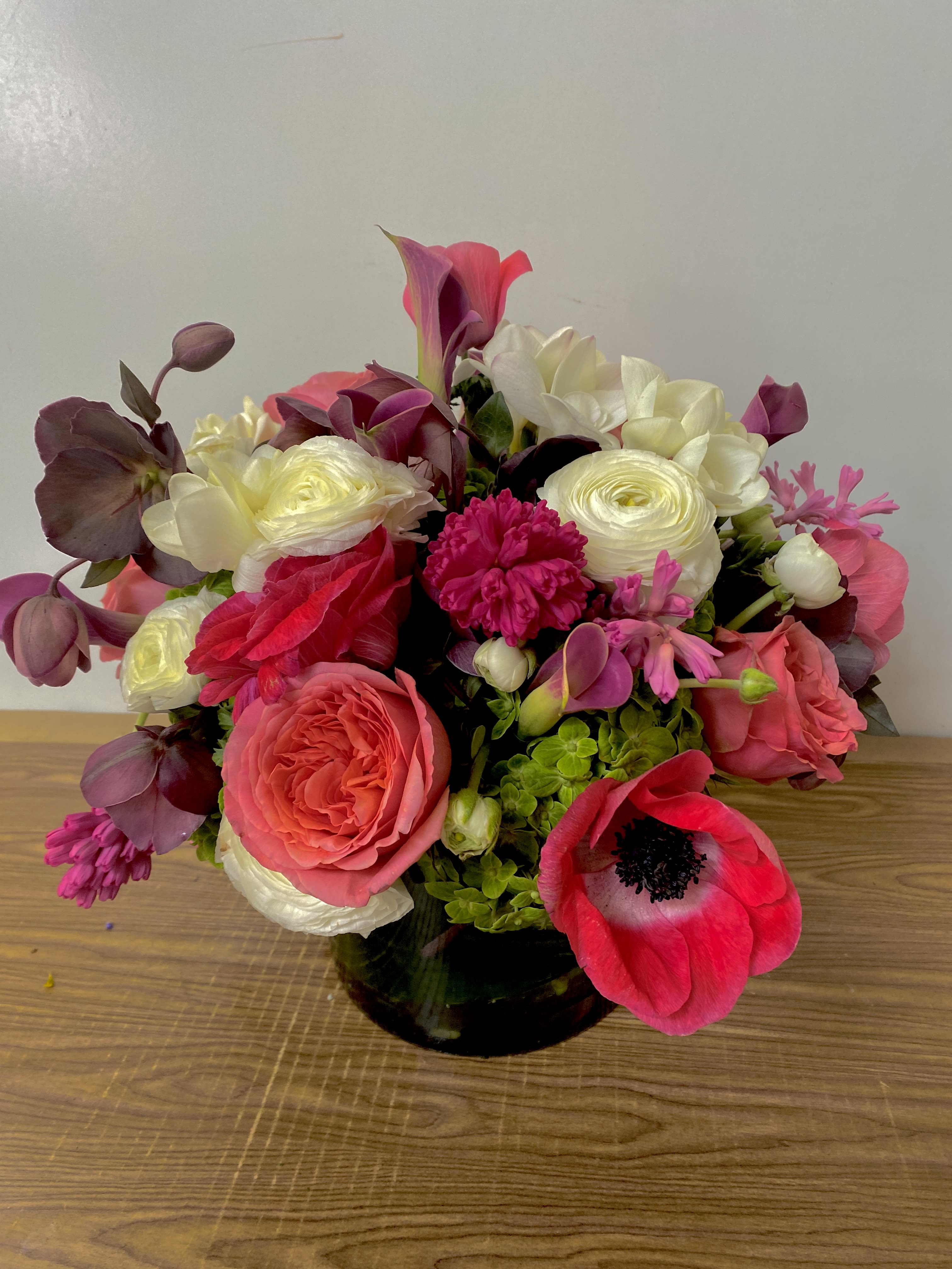 Mixed pink and white bouquet in a dark glass vase