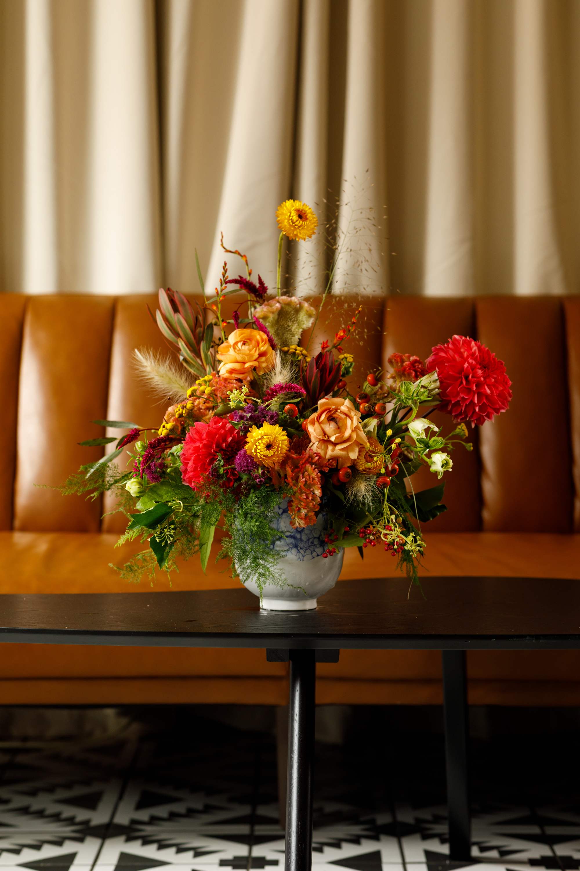 Colorful mixed flower arrangement in a white vase on a table