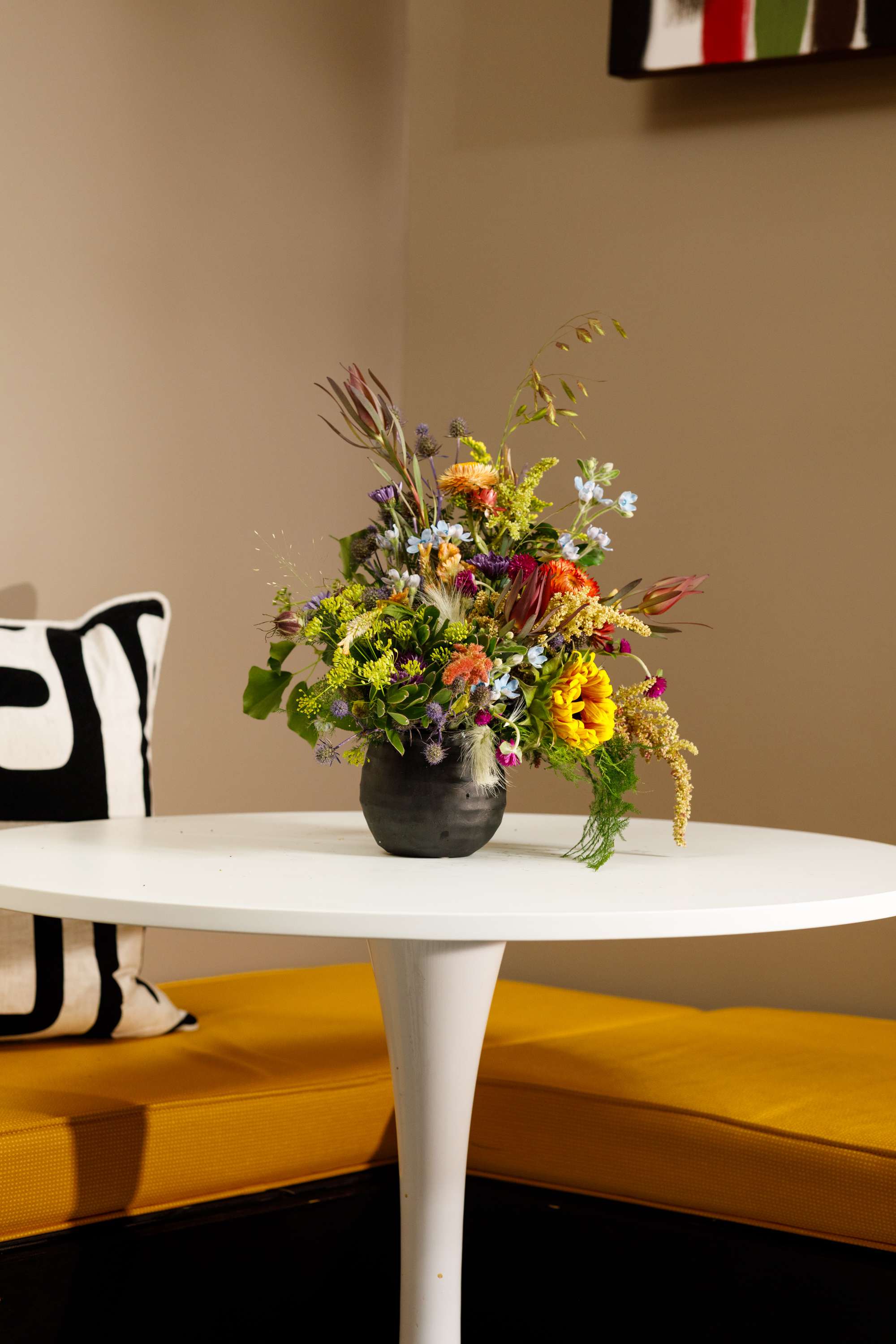 Mixed bouquet in a dark vase on a white table
