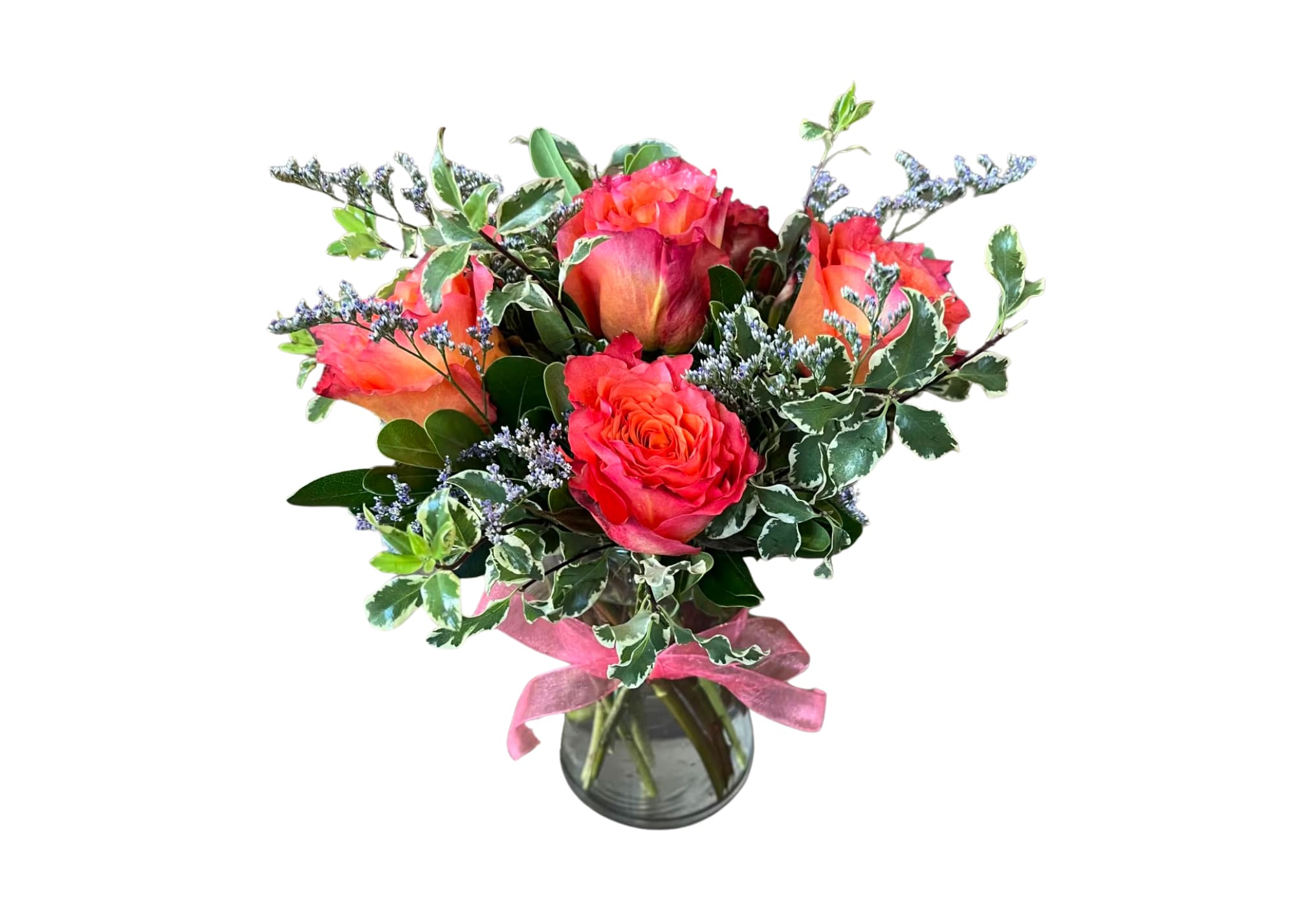 Bouquet of coral roses in a glass vase with a pink ribbon