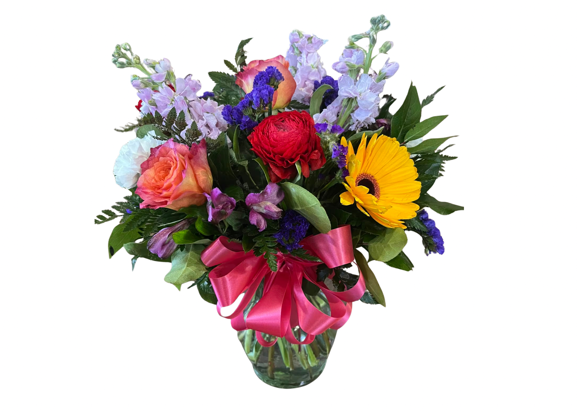 Bright mixed flower arrangement with yellow gerbera, roses, and red bloom in a clear vase with pink bow