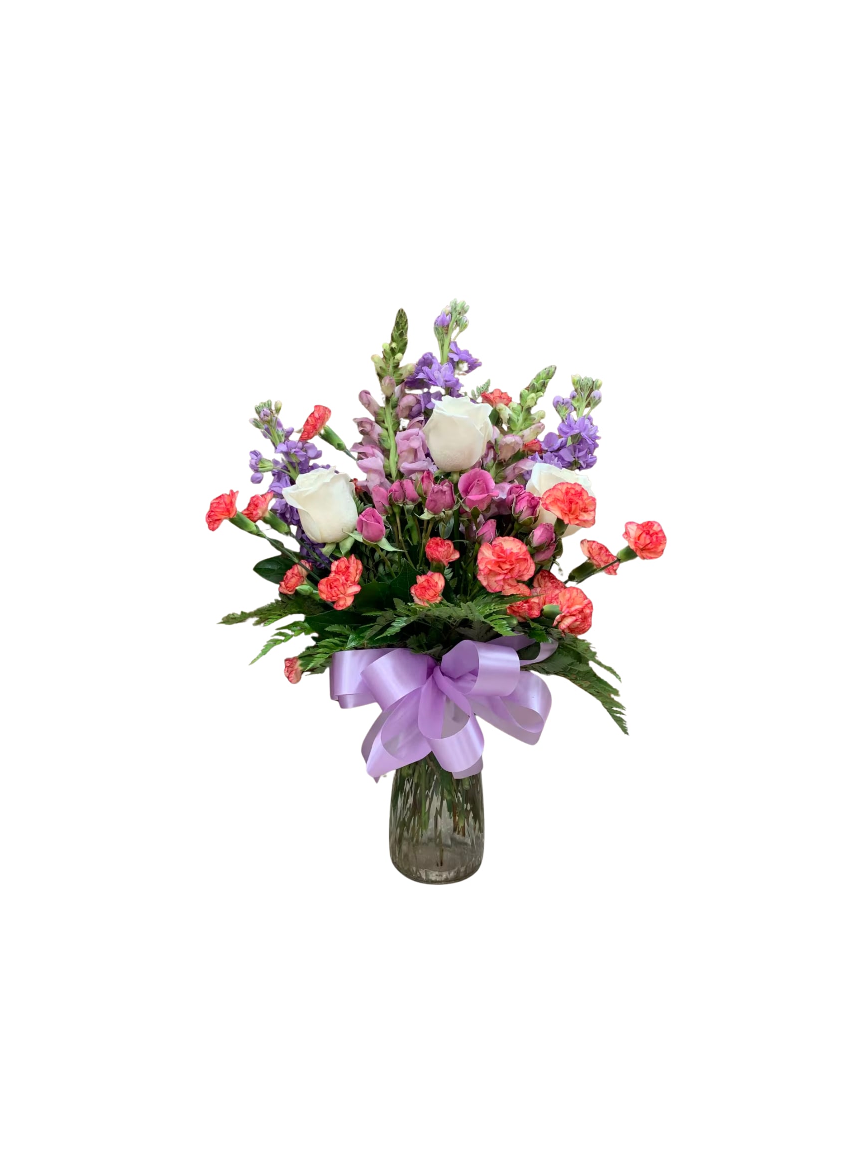 Bouquet of white roses, pink carnations, and purple flowers in a glass vase