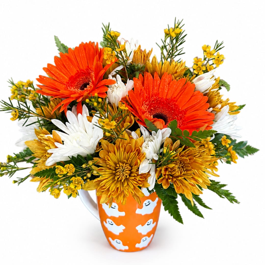 Orange and yellow mixed flower bouquet in a Halloween mug