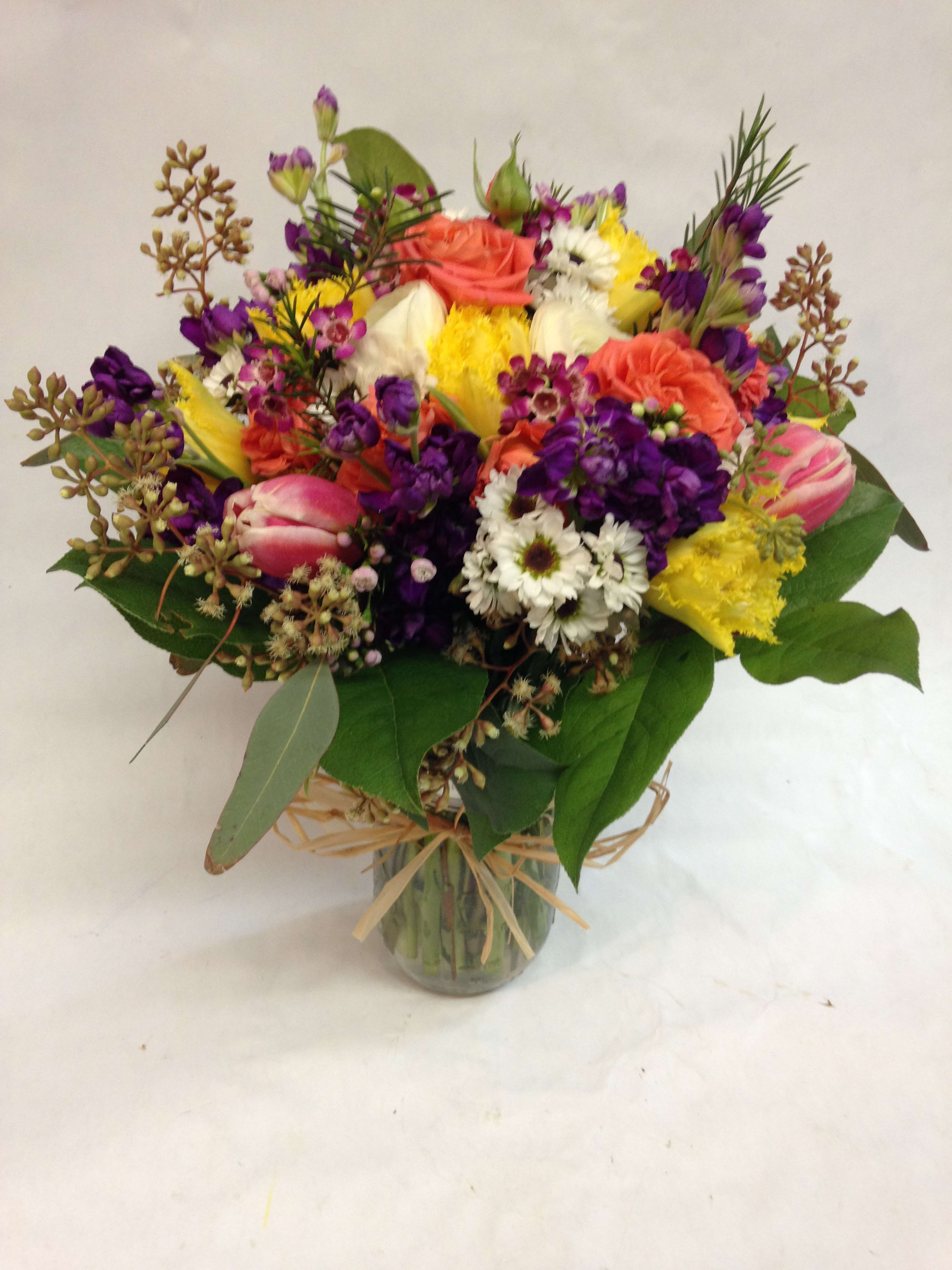Mixed bouquet of colorful flowers in a glass vase