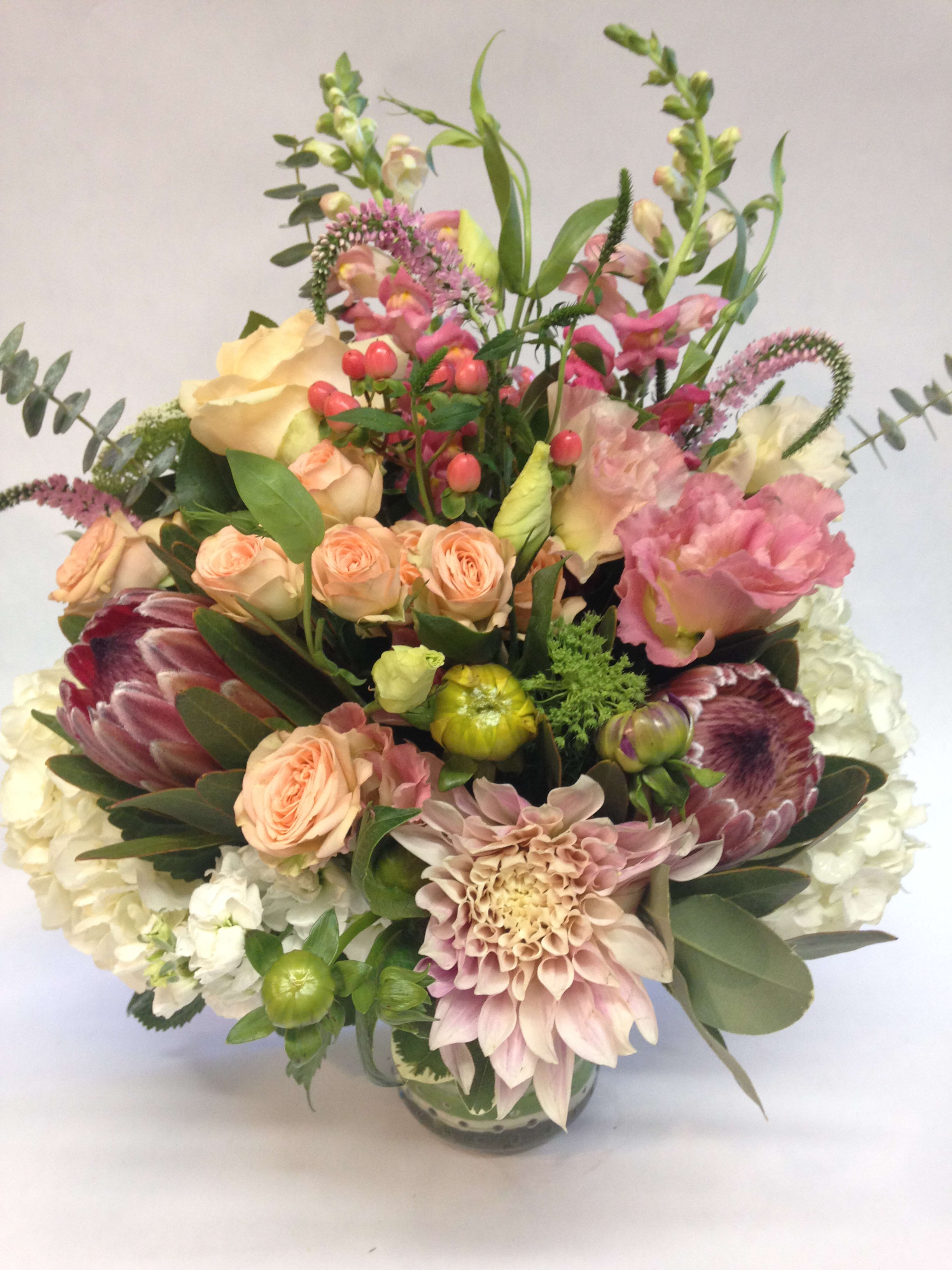 Mixed bouquet of pink, peach, and white flowers in a vase
