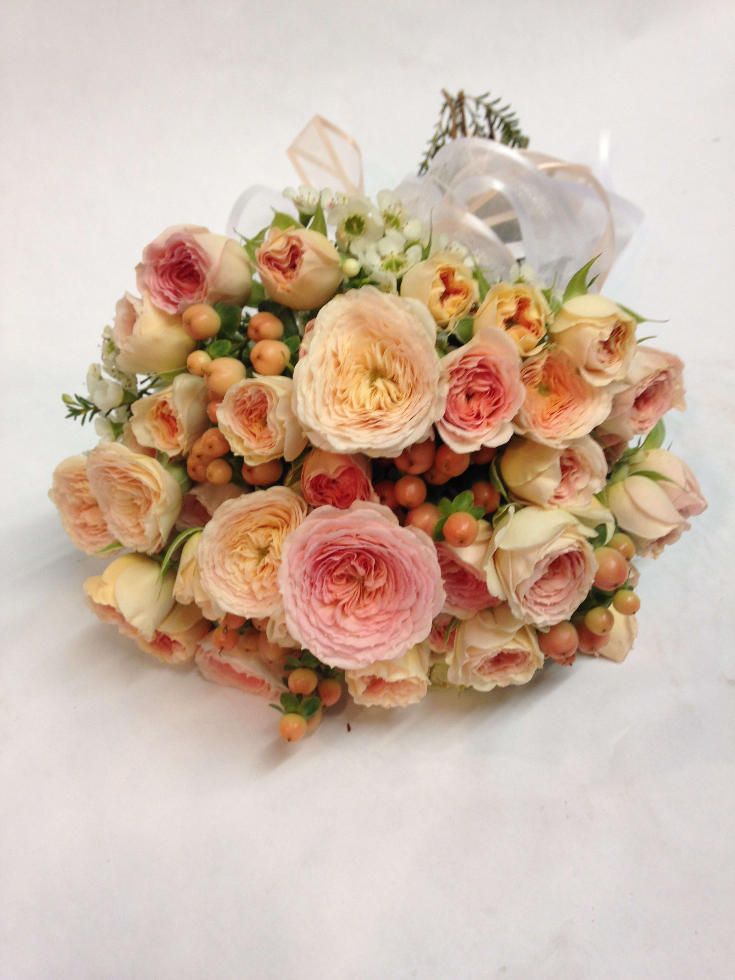 Bouquet of blush and peach roses with small white flowers