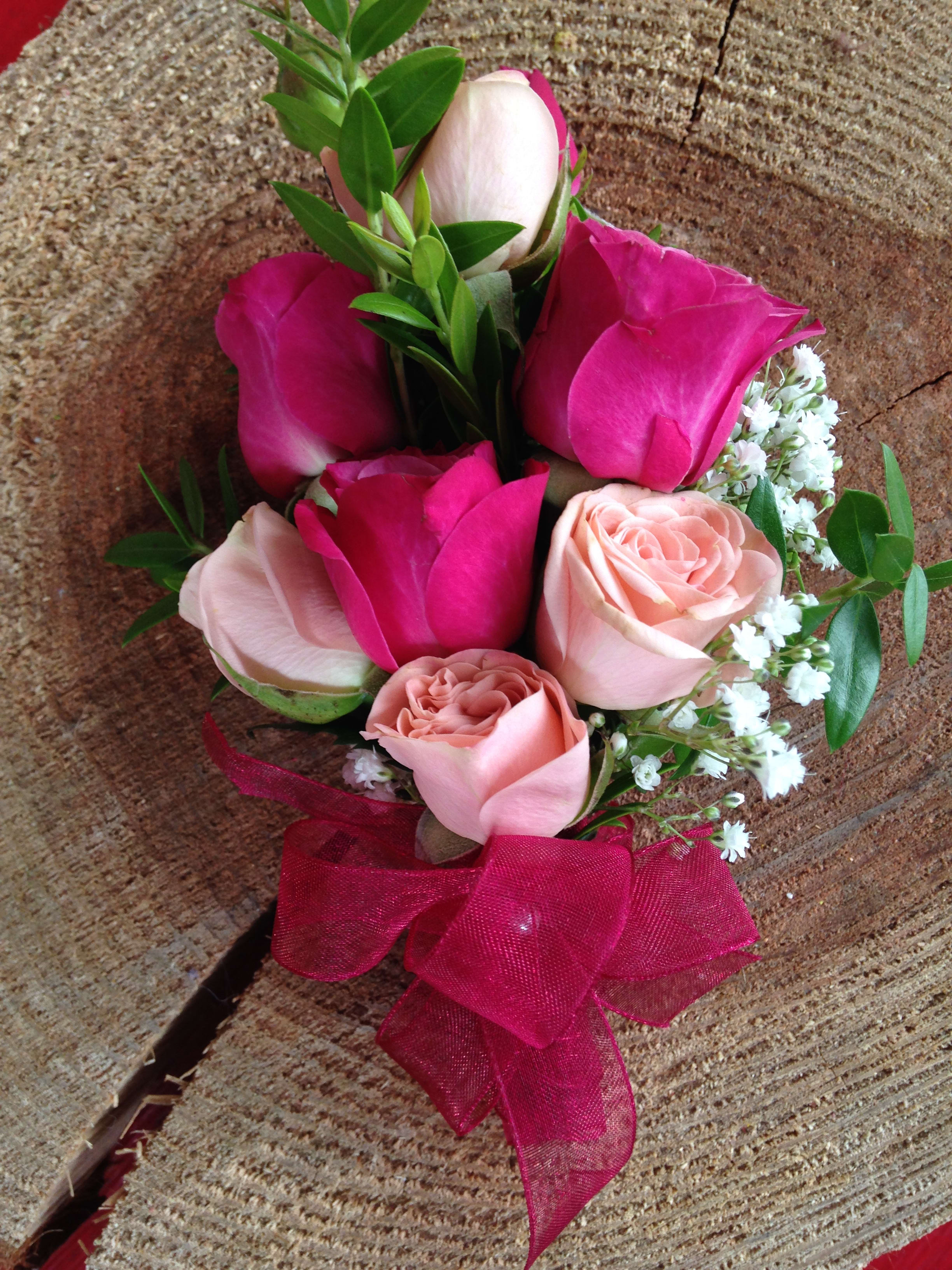 Small bouquet of pink and blush roses with a magenta ribbon