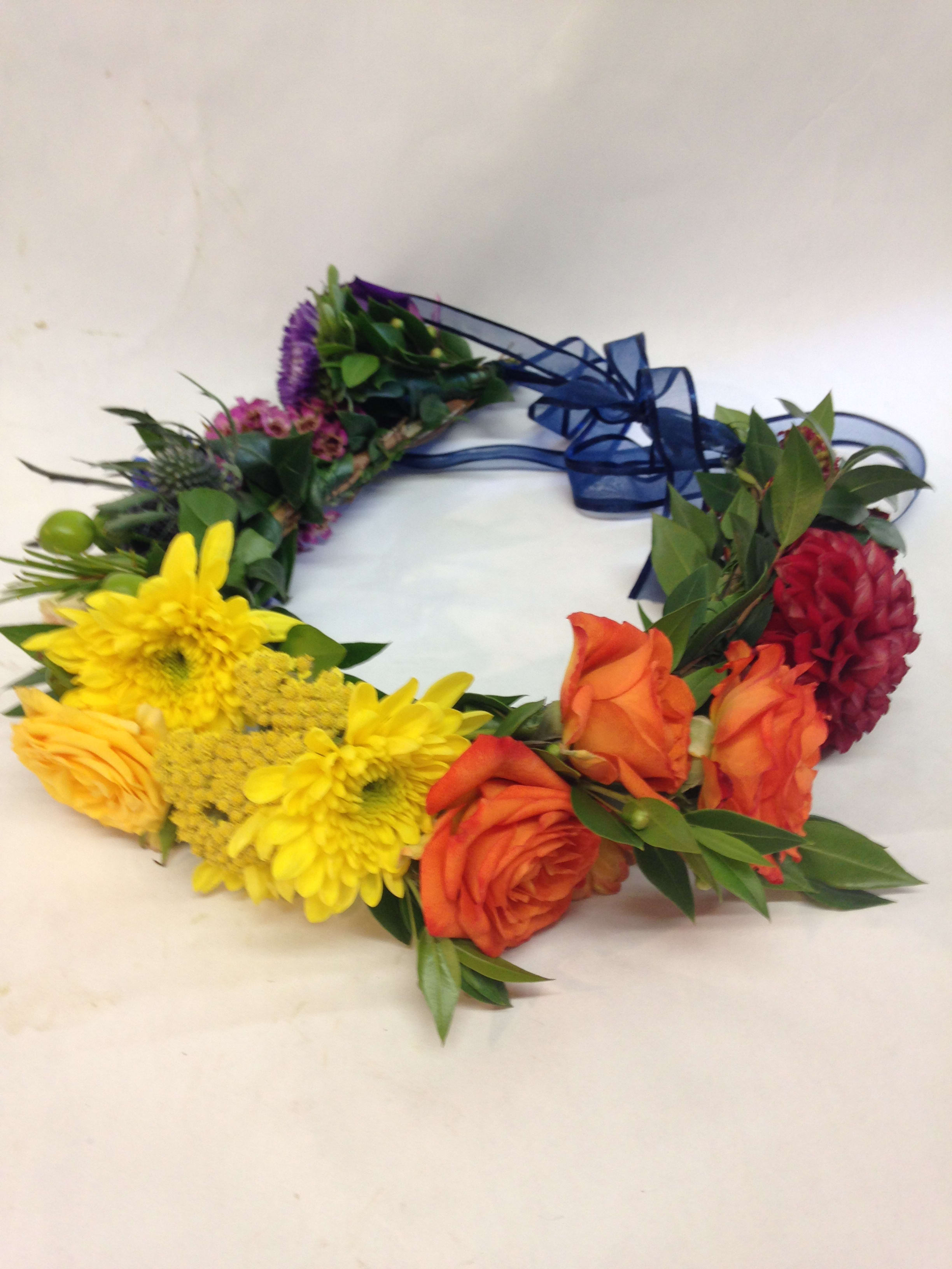 Colorful floral wreath with roses, chrysanthemums, and a blue ribbon