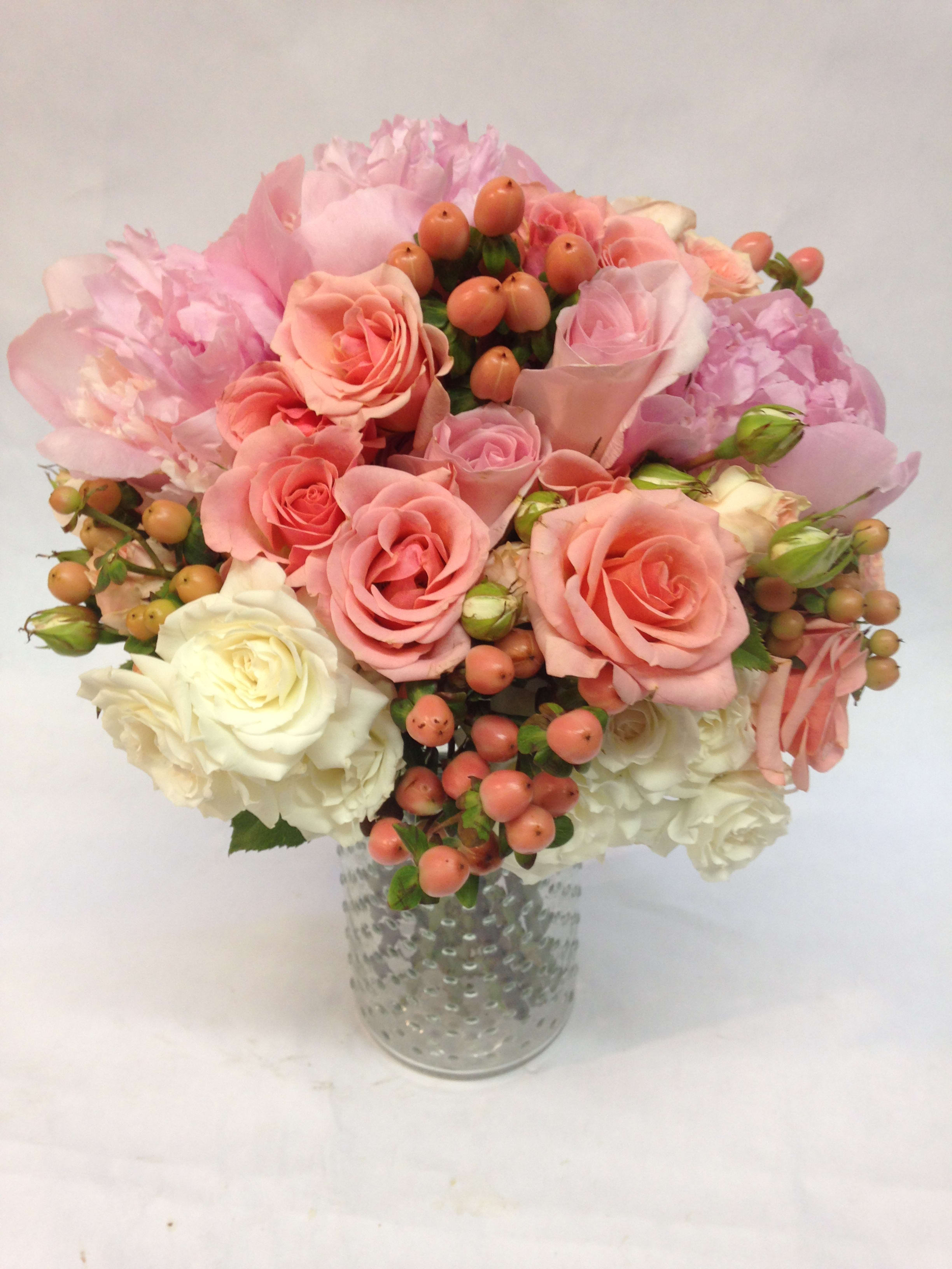 Pink and white rose bouquet in a textured glass vase