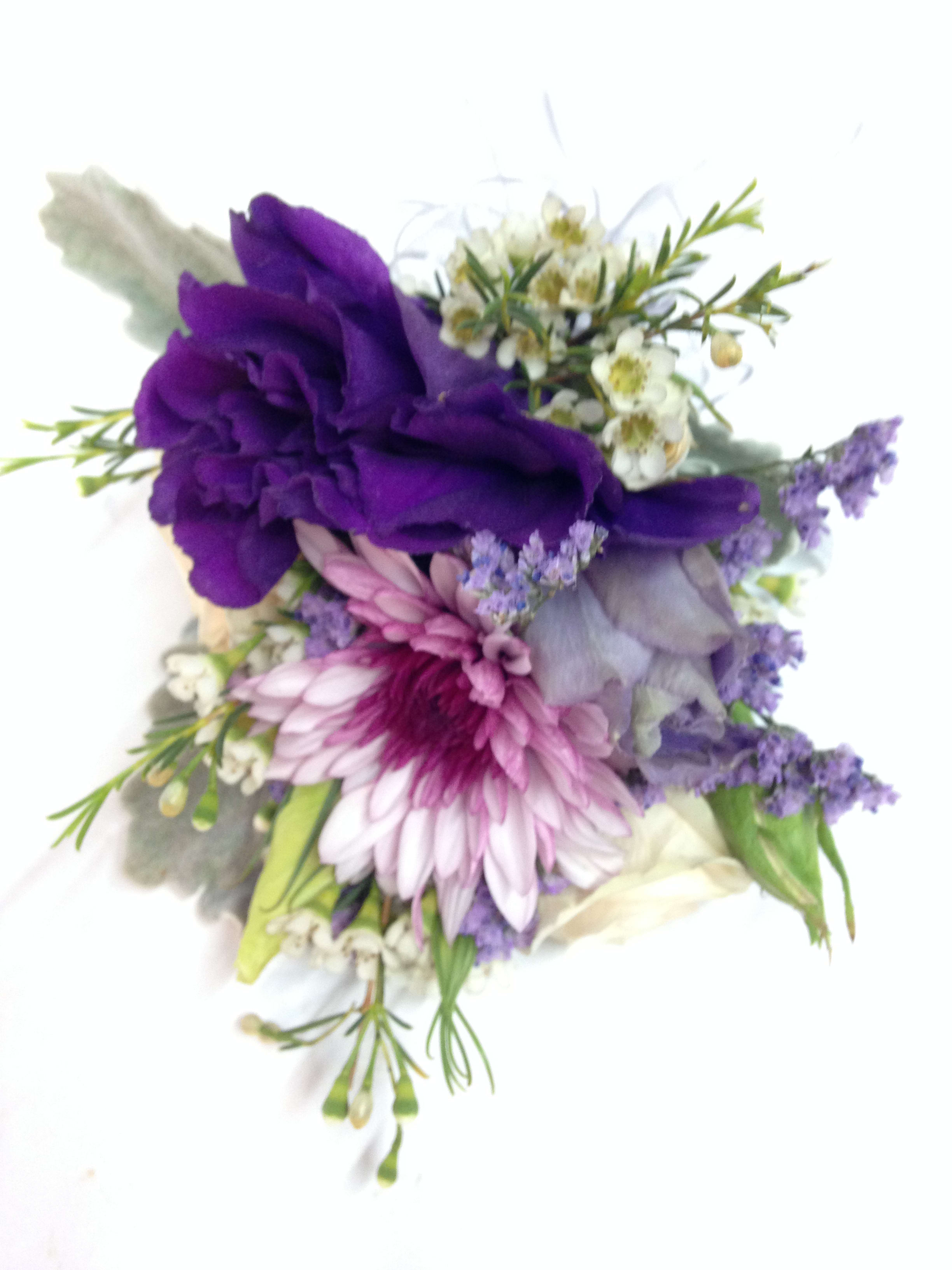 Purple and pink floral corsage with small white blossoms
