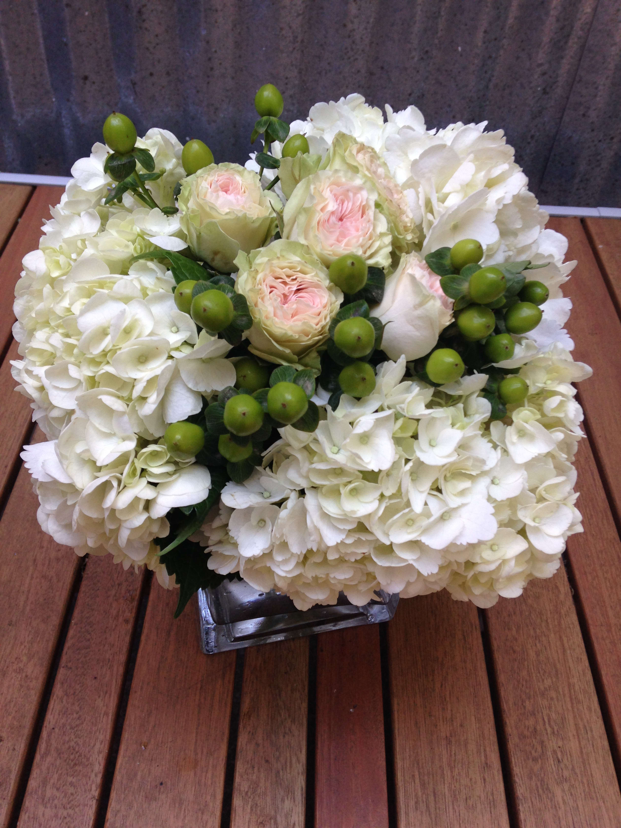 White hydrangea and pale pink roses in a square glass vase