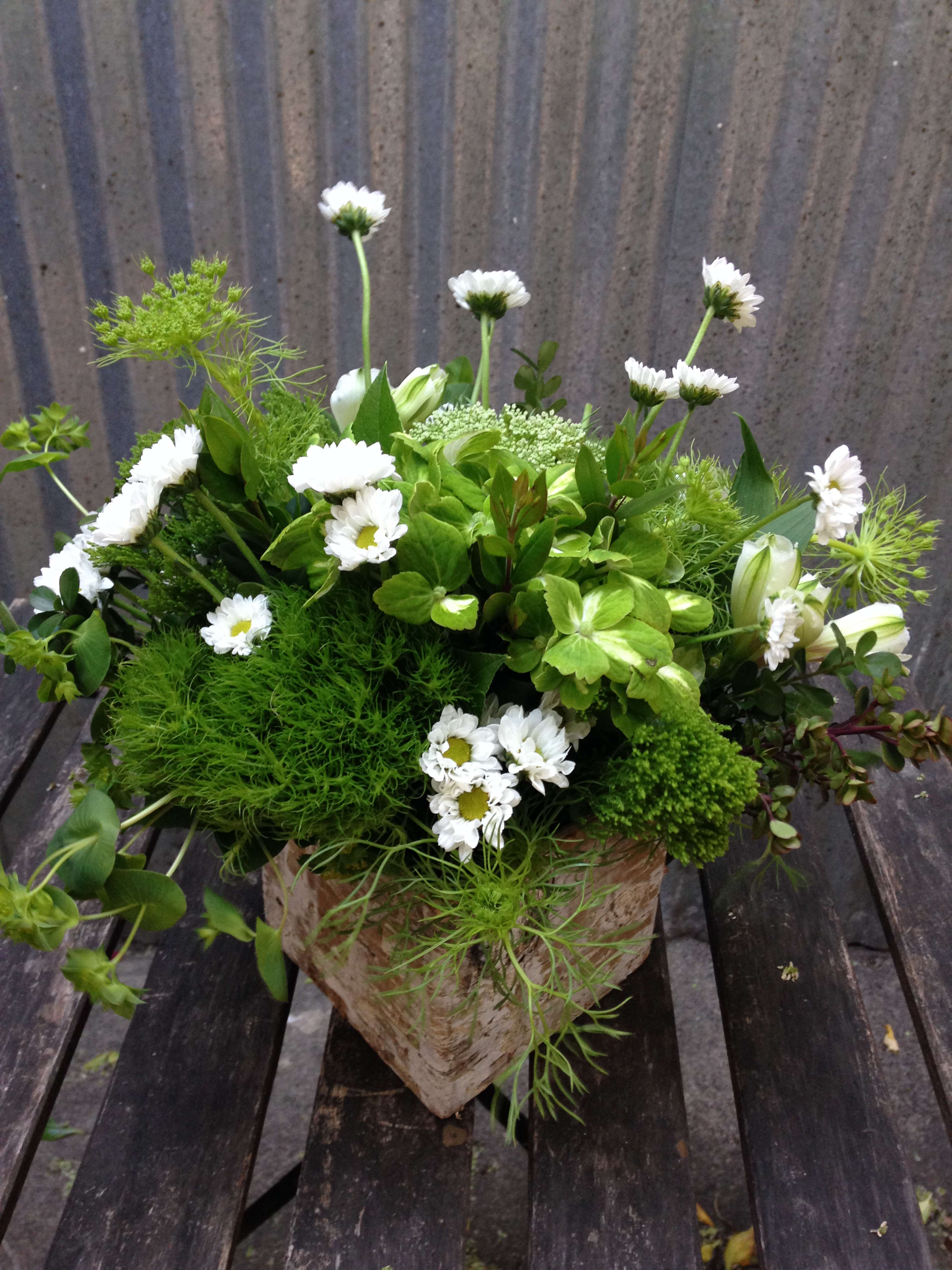 White daisy bouquet in a rustic paper-wrapped container
