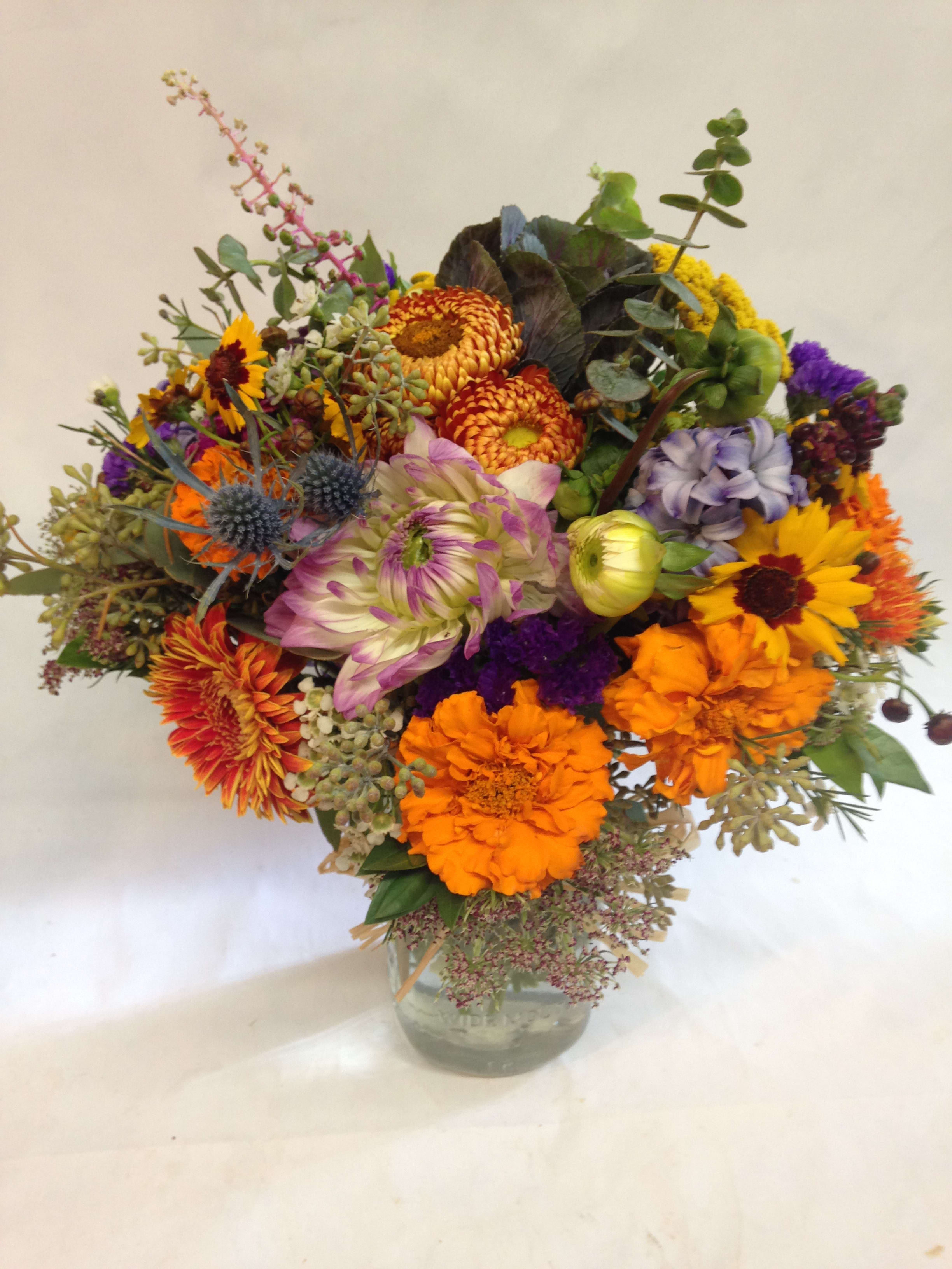 Mixed bouquet of bright flowers in a clear glass vase