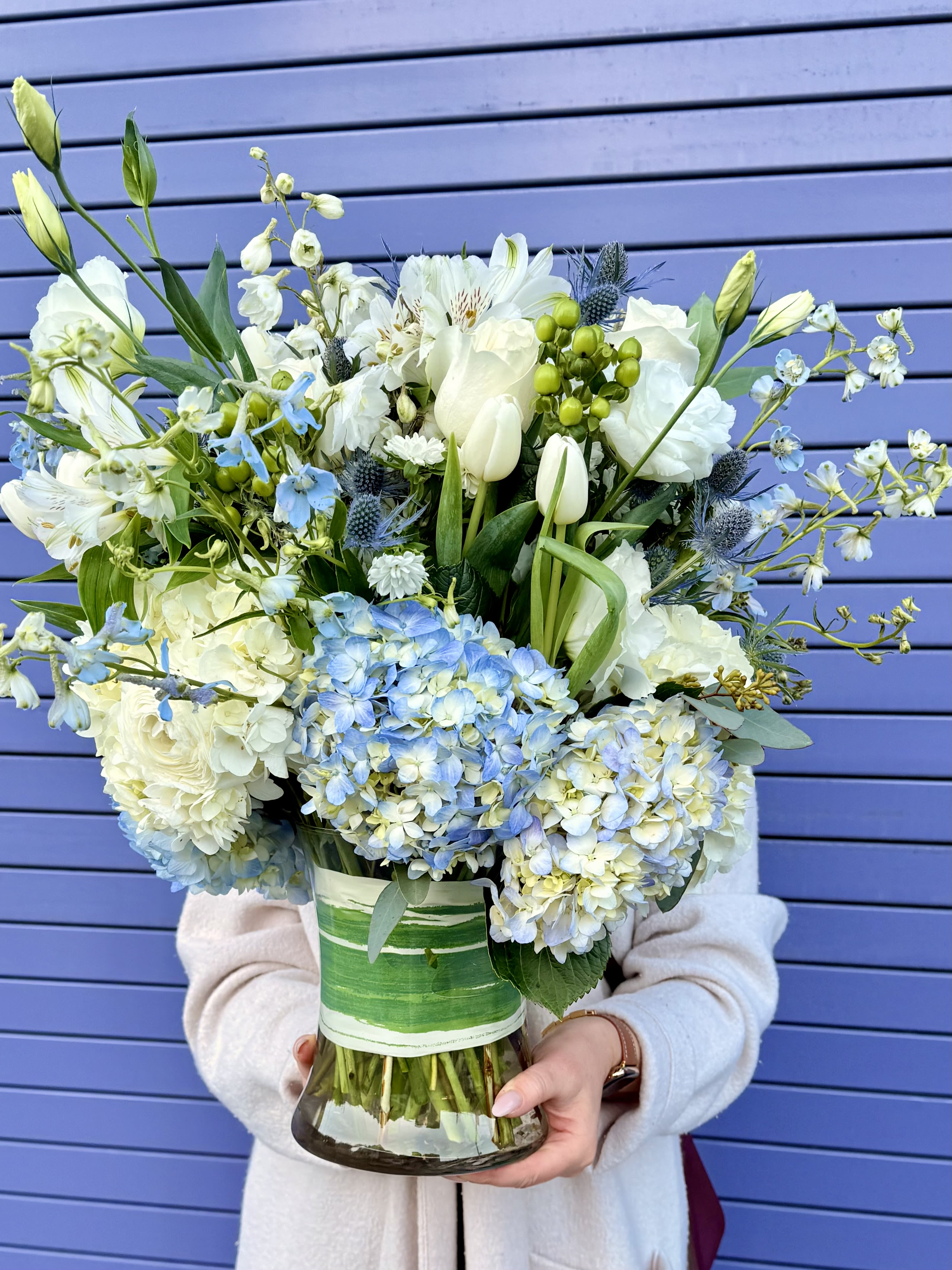 Large bouquet of white and blue flowers in a glass vase