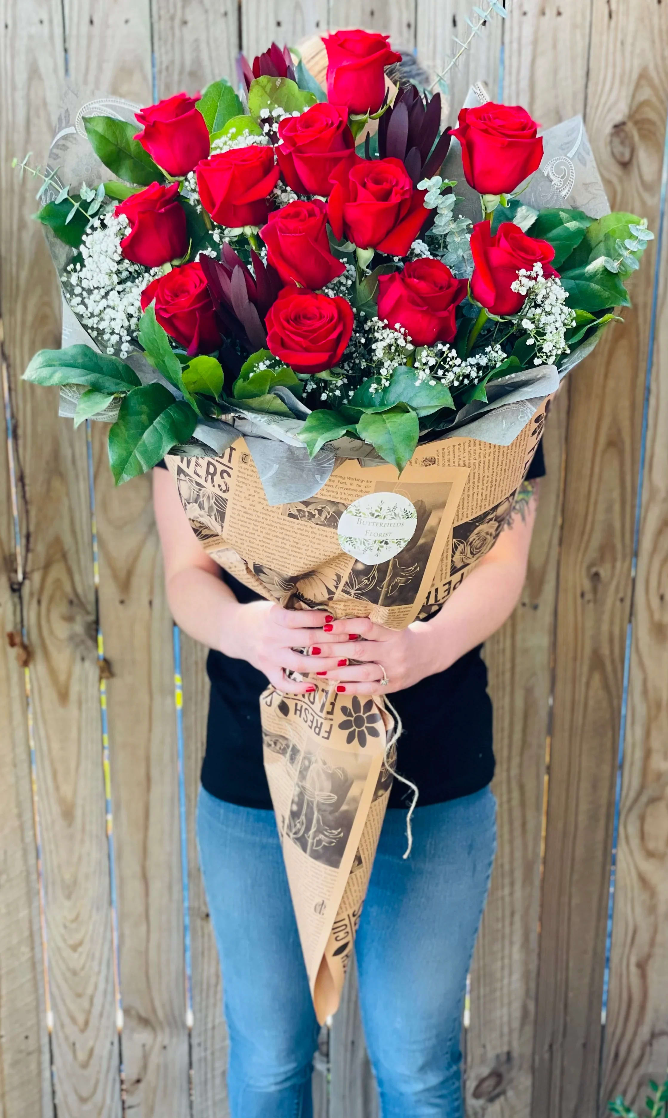 Large bouquet of red roses wrapped in brown paper