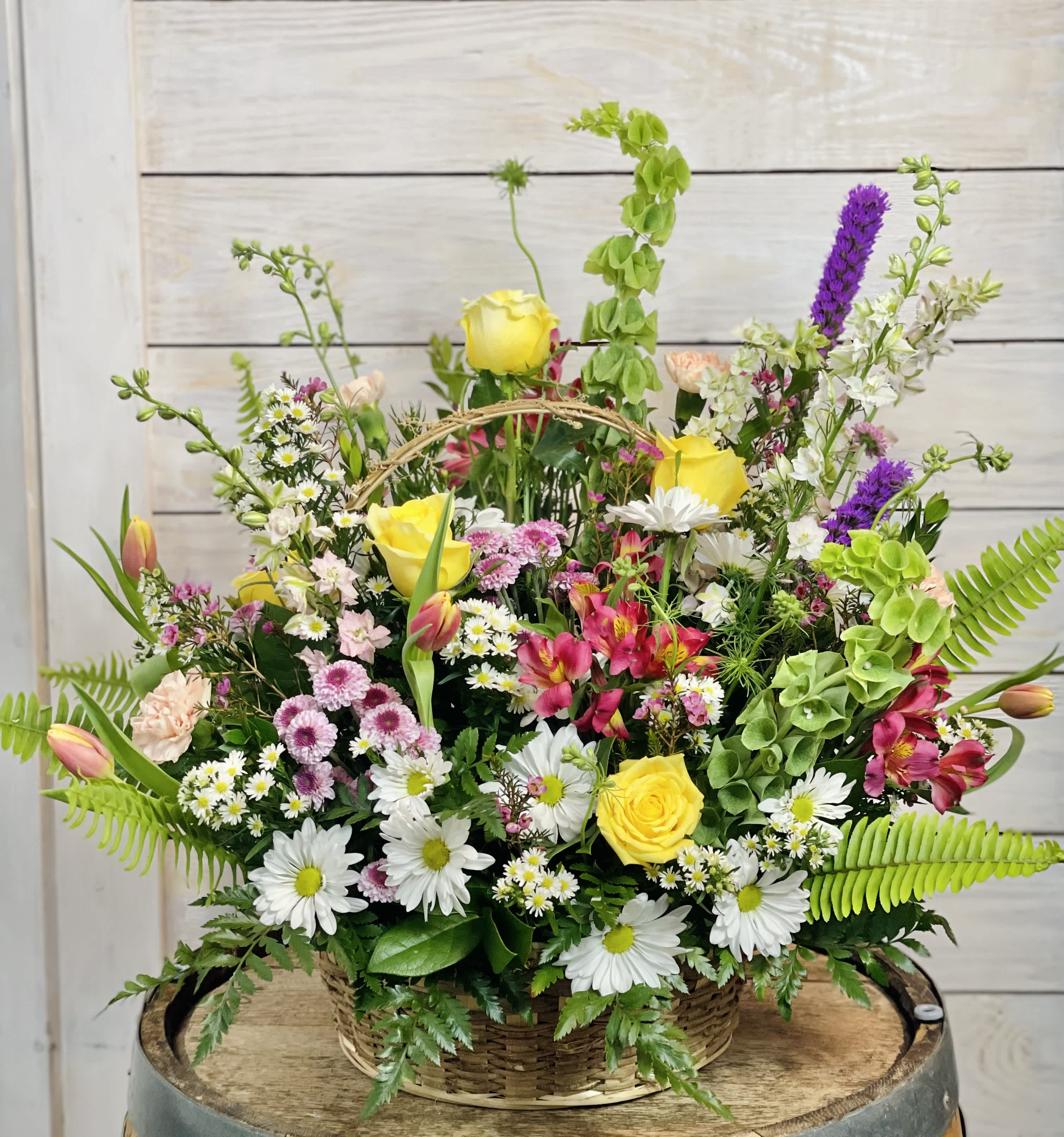 Mixed flower basket with yellow roses, daisies, and pink blooms