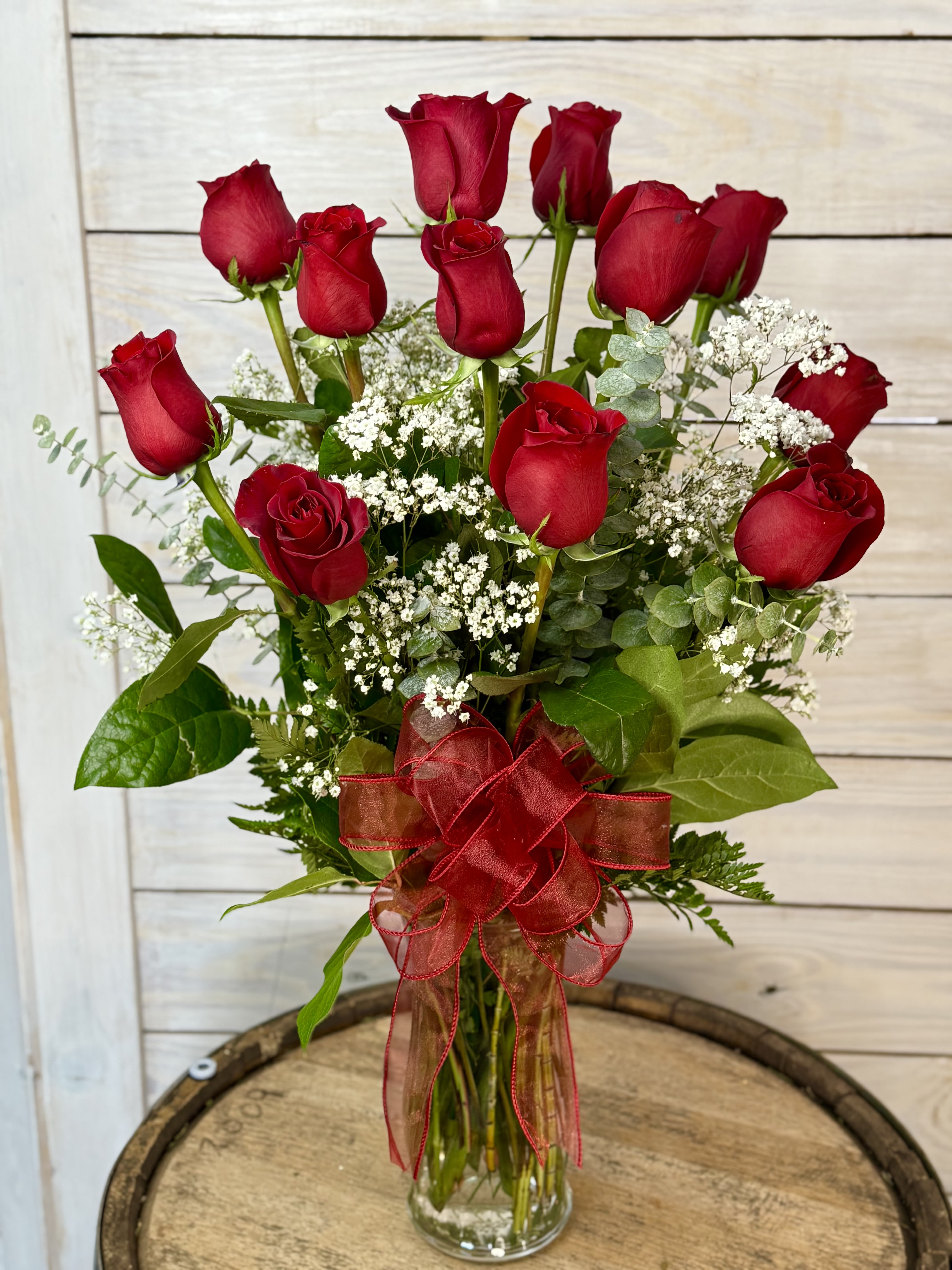 Bouquet of red roses with baby's breath in a glass vase