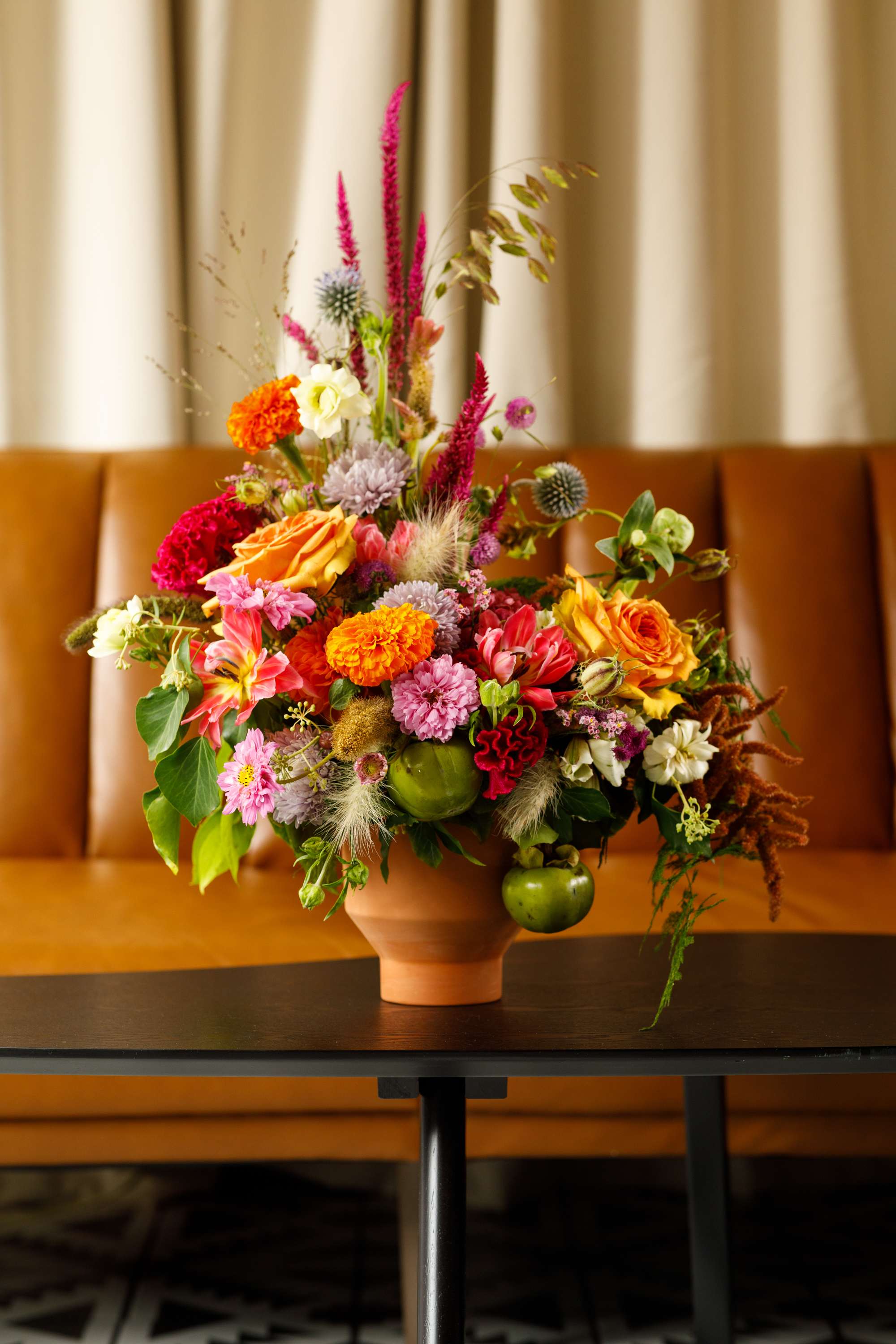 Colorful mixed flower arrangement in a terracotta vase on a table