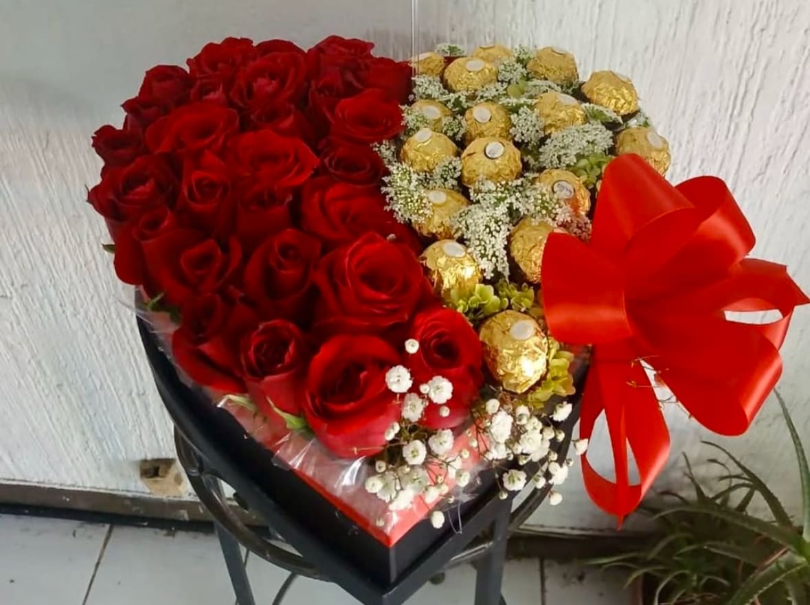 Heart-shaped bouquet of red roses and gold-wrapped chocolates with a red bow