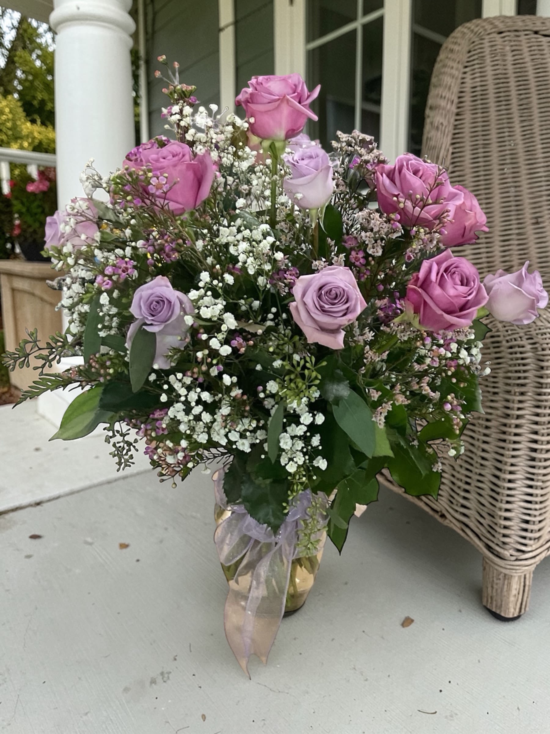 Dozen Lavender Roses - Lavender Whisper is a soft, romantic design built around elegant lavender roses, accented with airy textures of baby’s breath, waxflower, and fresh greenery. The palette stays gentle and cohesive, creating a look that feels calm, polished, and quietly expressive.  There’s a lightness to this arrangement—nothing heavy or overworked—just a clean, graceful composition that settles naturally into any space.  A beautiful choice for birthdays, anniversaries, sympathy, thinking of you, or simply sending something meaningful without saying too much.  Each arrangement is designed with the freshest seasonal stems available. Varieties may vary slightly while maintaining the same soft lavender palette and overall style.  Available for local flower delivery through Aspen Tower Florist, serving Greensburg and Shelbyville along with Rushville, Batesville, Westport, Oldenburg, St. Paul, Waldron, and Milroy.