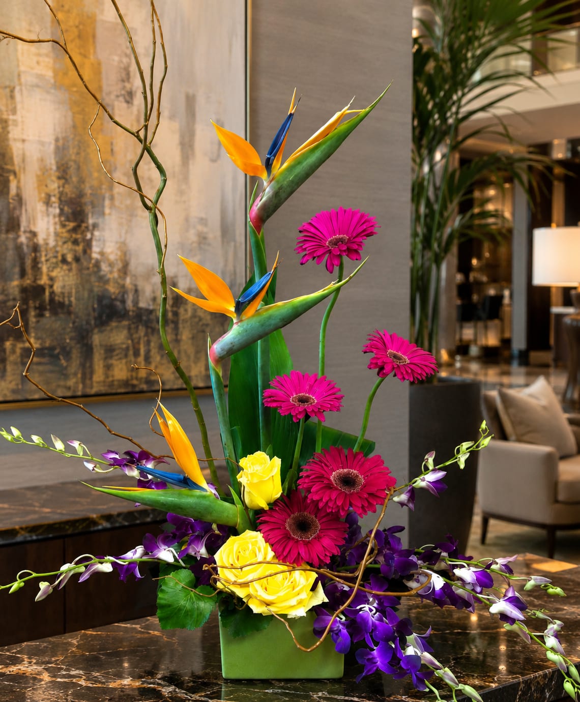 SPECIAL ORDER Pacific Sunset Arrangement - Bring the beauty of the tropics home with Pacific Sunset, a bold floral design featuring birds of paradise, gerbera daisies, roses, dendrobium orchids, tropical foliage, and decorative curly willow accents. Inspired by vibrant island sunsets, this arrangement blends brilliant shades of orange, yellow, fuchsia, purple, and green into a striking display full of color, movement, and contemporary style.  Perfect for birthdays, congratulations, thank you gifts, housewarmings, offices, corporate gifts, and special celebrations, Pacific Sunset is designed for those who appreciate unique floral artistry. The dramatic birds of paradise create an exotic focal point, while orchids, roses, and gerberas provide texture, depth, and lasting visual impact.  Hand-designed by Aspen Tower Florist and available for local delivery in Greensburg, Batesville, Shelbyville, Rushville, Westport, Hope, North Vernon, and surrounding communities.  Flowers and container may vary based on availability, but the overall tropical style, color palette, and design will be maintained as closely as possible.