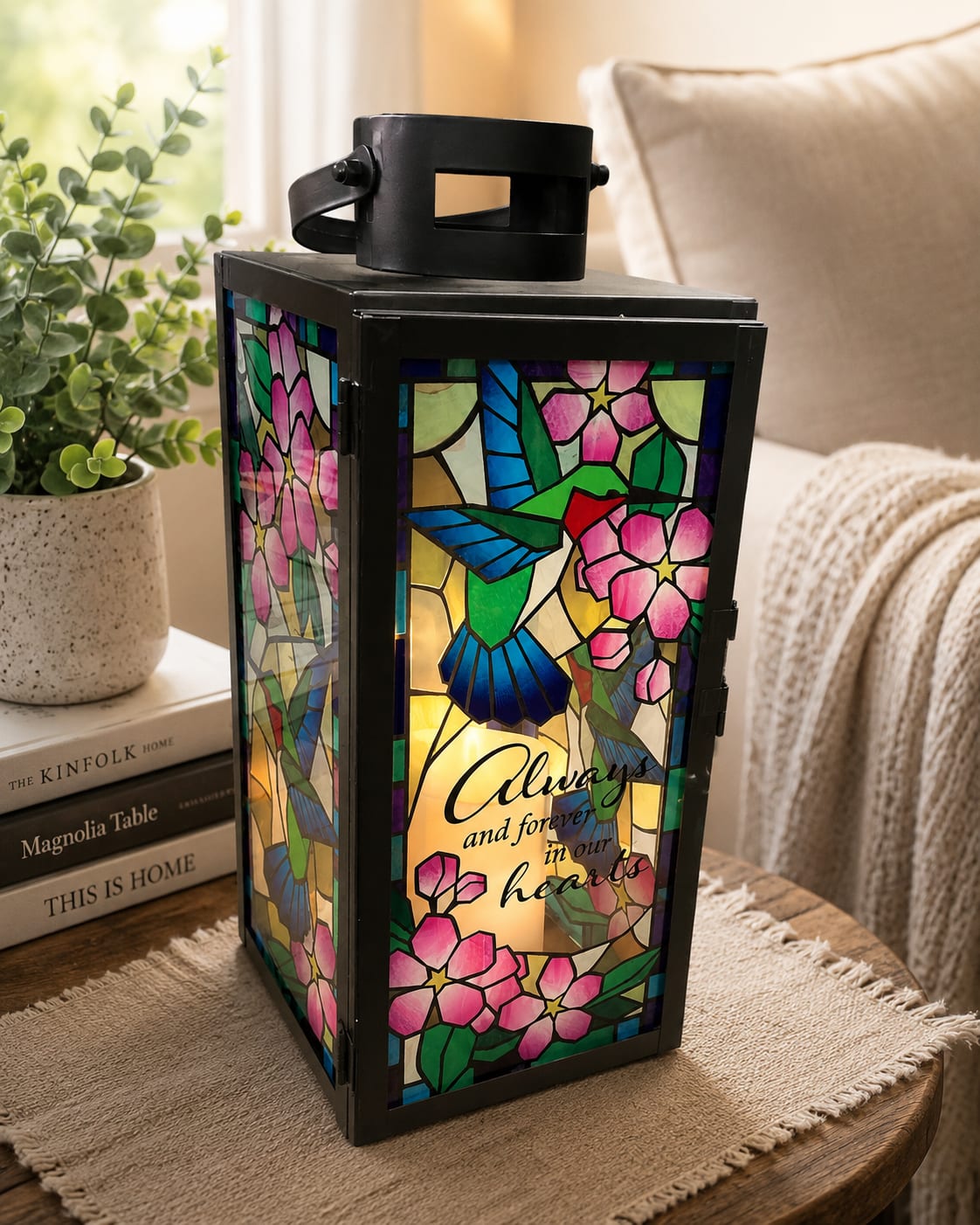 Always and Forever - Honor a cherished life with Always &amp; Forever, a memorial lantern tribute featuring a stained-glass-style hummingbird design and the sentiment, “Always and Forever in Our Hearts.” This meaningful keepsake offers comfort, remembrance, and a lasting expression of love.  The Standard version includes the lantern by itself for display at home, on a remembrance table, or as a sympathy gift.  The Deluxe version features the lantern professionally designed within a fresh floral arrangement, combining flowers and keepsake remembrance in one thoughtful tribute.  The Premium version showcases the lantern within a larger, more abundant floral arrangement designed to create a beautiful focal point for funeral services, memorial services, visitations, and celebrations of life.  Perfect for sympathy, memorial services, funeral services, celebration of life gatherings, remembrance gifts, bereavement, anniversaries of loss, and lasting home memorial displays.  Because each floral tribute is individually designed, flower varieties, colors, and accents may vary based on availability. While individual elements may differ, the overall style, theme, and presentation of Always &amp; Forever will be maintained.
