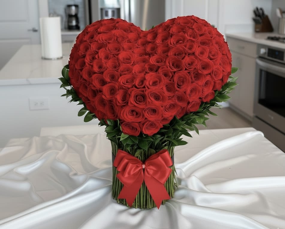 Heart-shaped bouquet of red roses with a red ribbon
