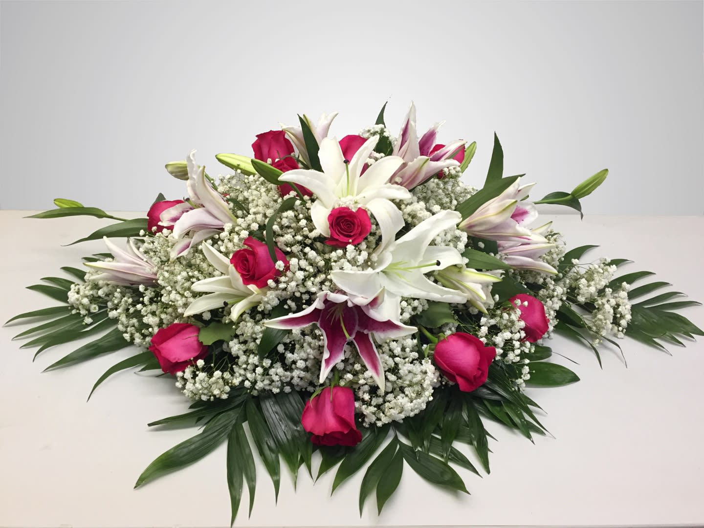 Low floral arrangement with white lilies and pink roses