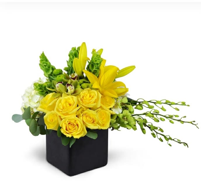 Yellow roses and lilies in a black square vase