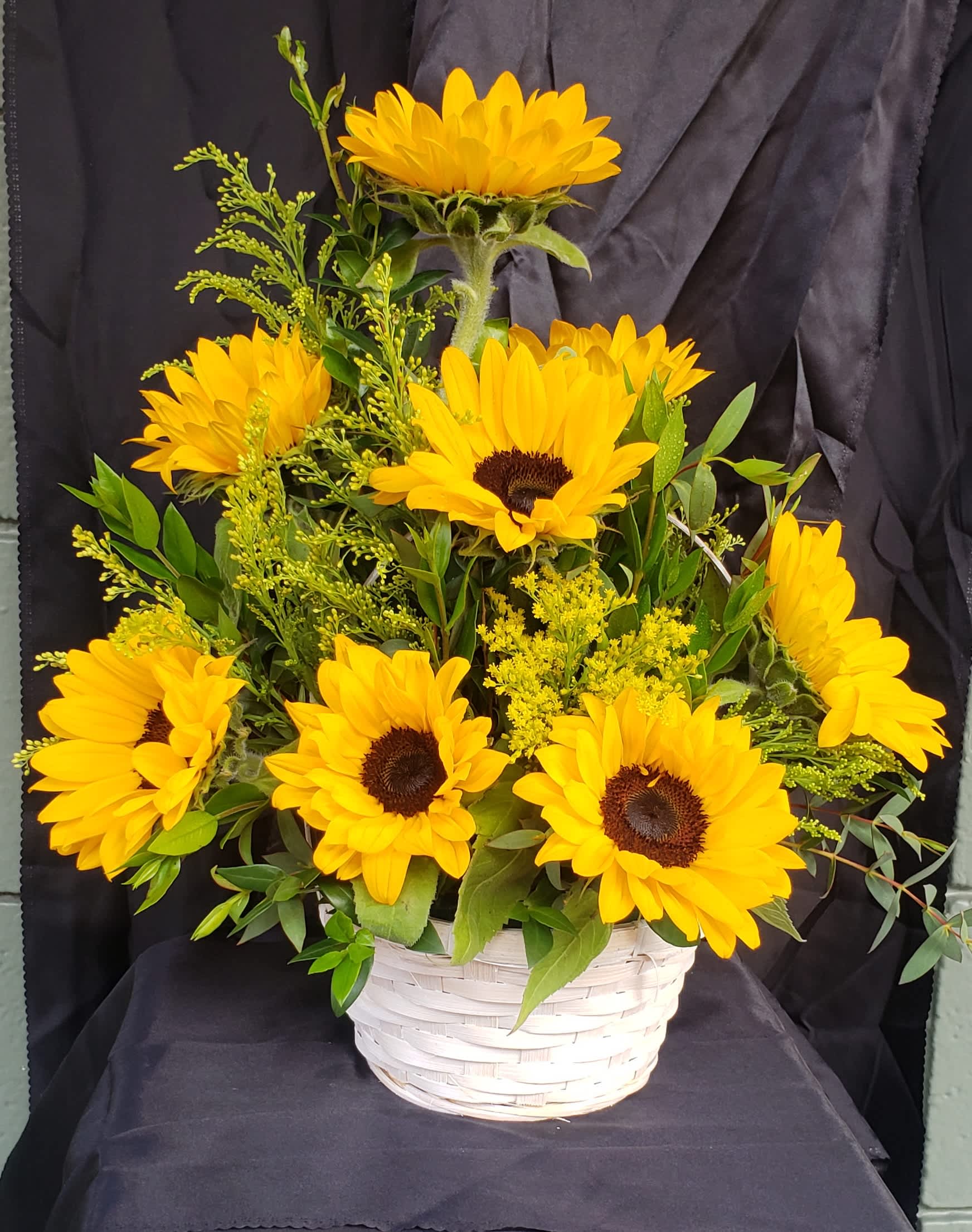 Yellow sunflowers arranged in a white basket