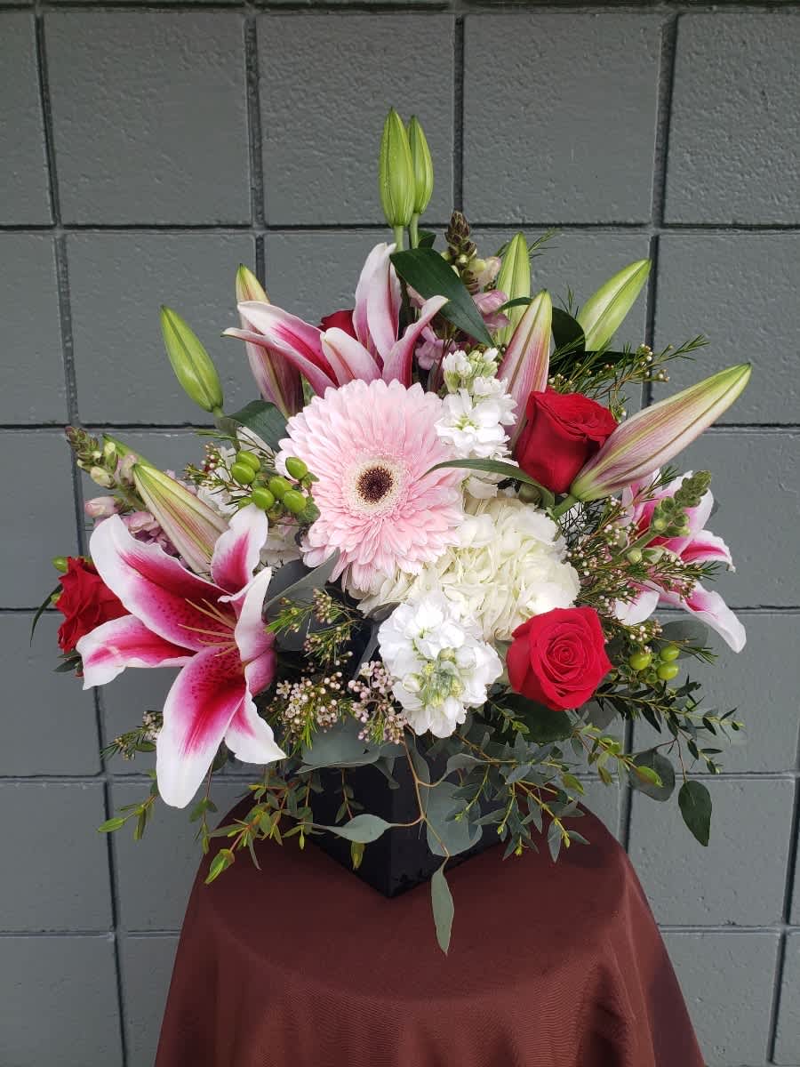 Mixed bouquet with pink lilies, red roses, and a pale pink gerbera daisy