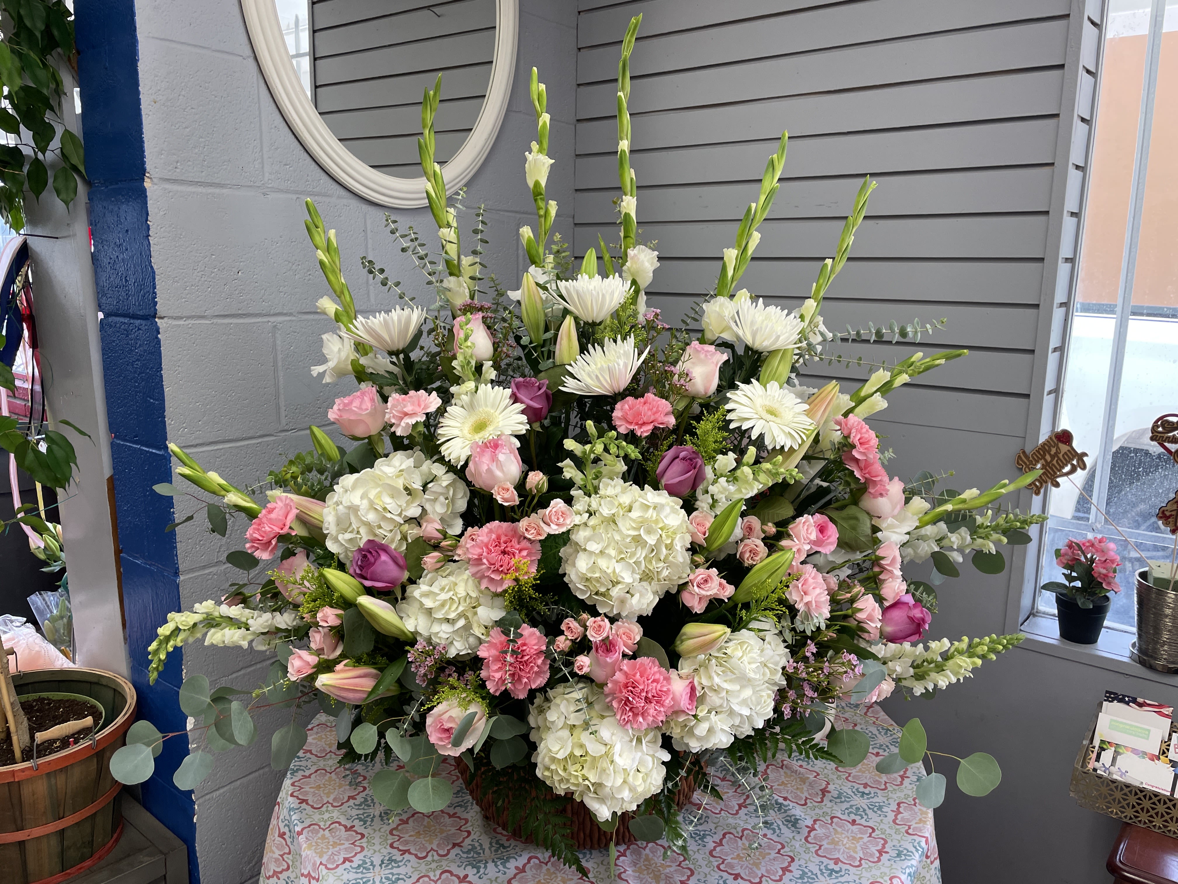 Large pink and white floral arrangement with lilies, roses, and hydrangeas