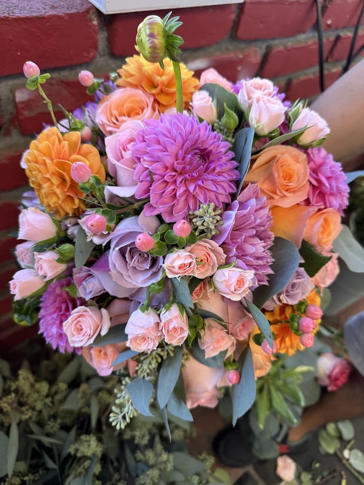 Bouquet of pink, lavender, and orange flowers with blue-gray foliage