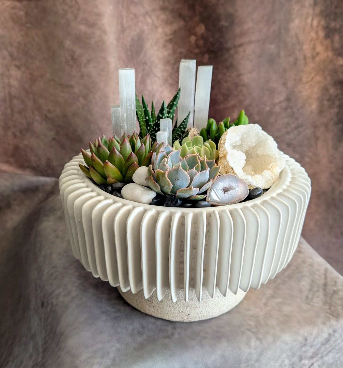 Succulent arrangement in a ribbed white planter with crystal accents